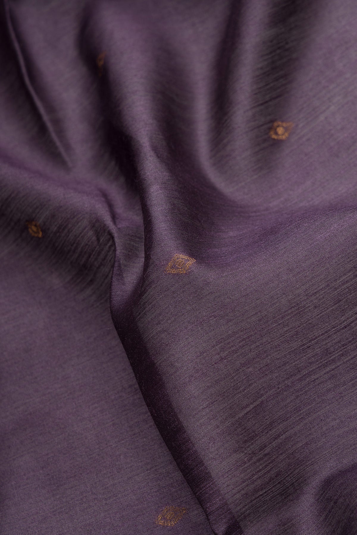Close up of Violet Dual Tone Tussar Silk Saree with Zari Butta on the body and Ikat Border.  displaying folds