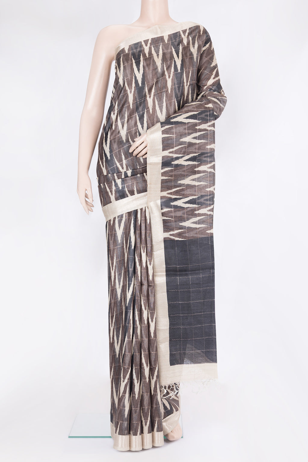 Brown Tussar Silk Saree with Ikat Print on the body and Zari Border.  displayed on a mannequin