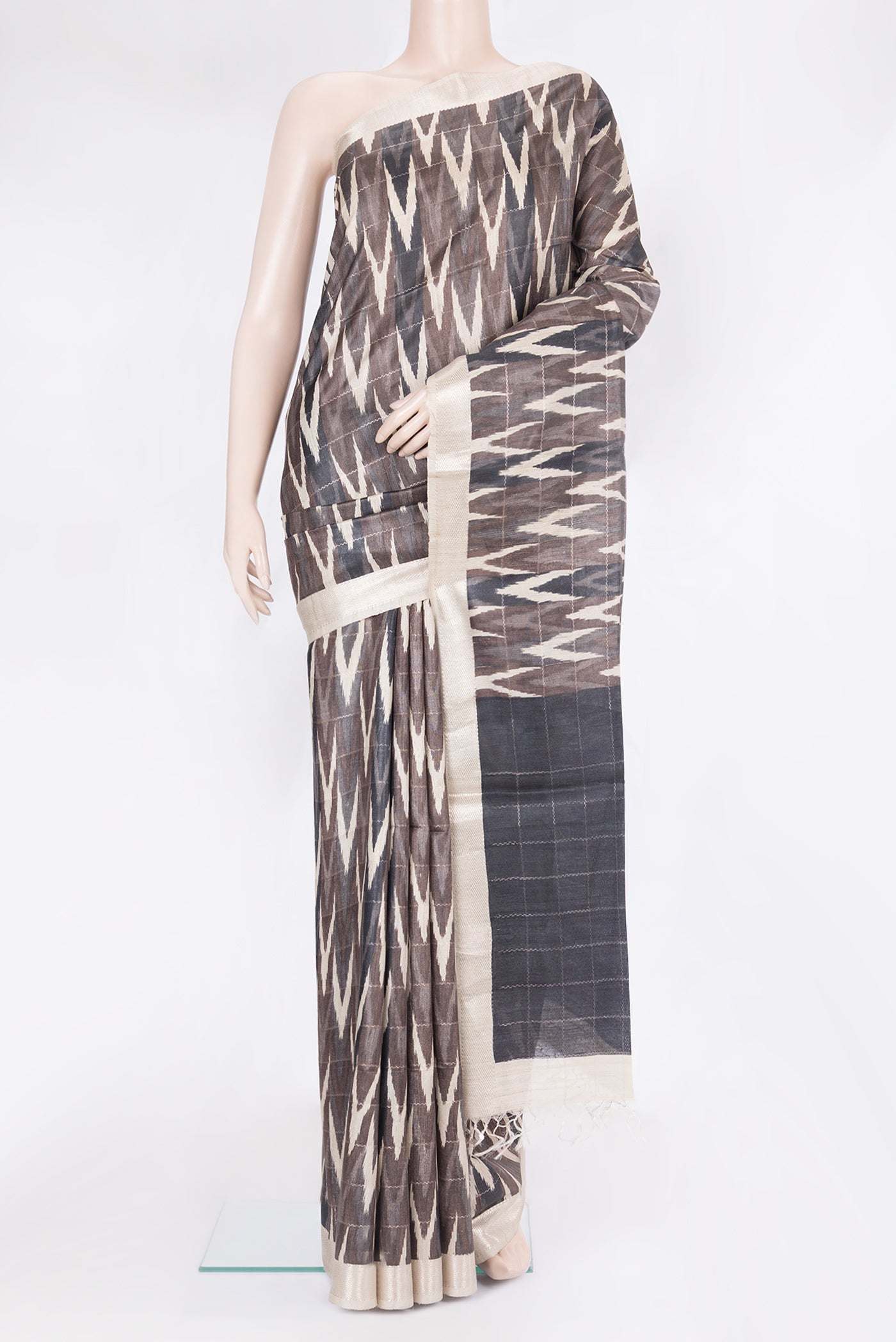 Brown Tussar Silk Saree with Ikat Print on the body and Zari Border.  displayed on a mannequin