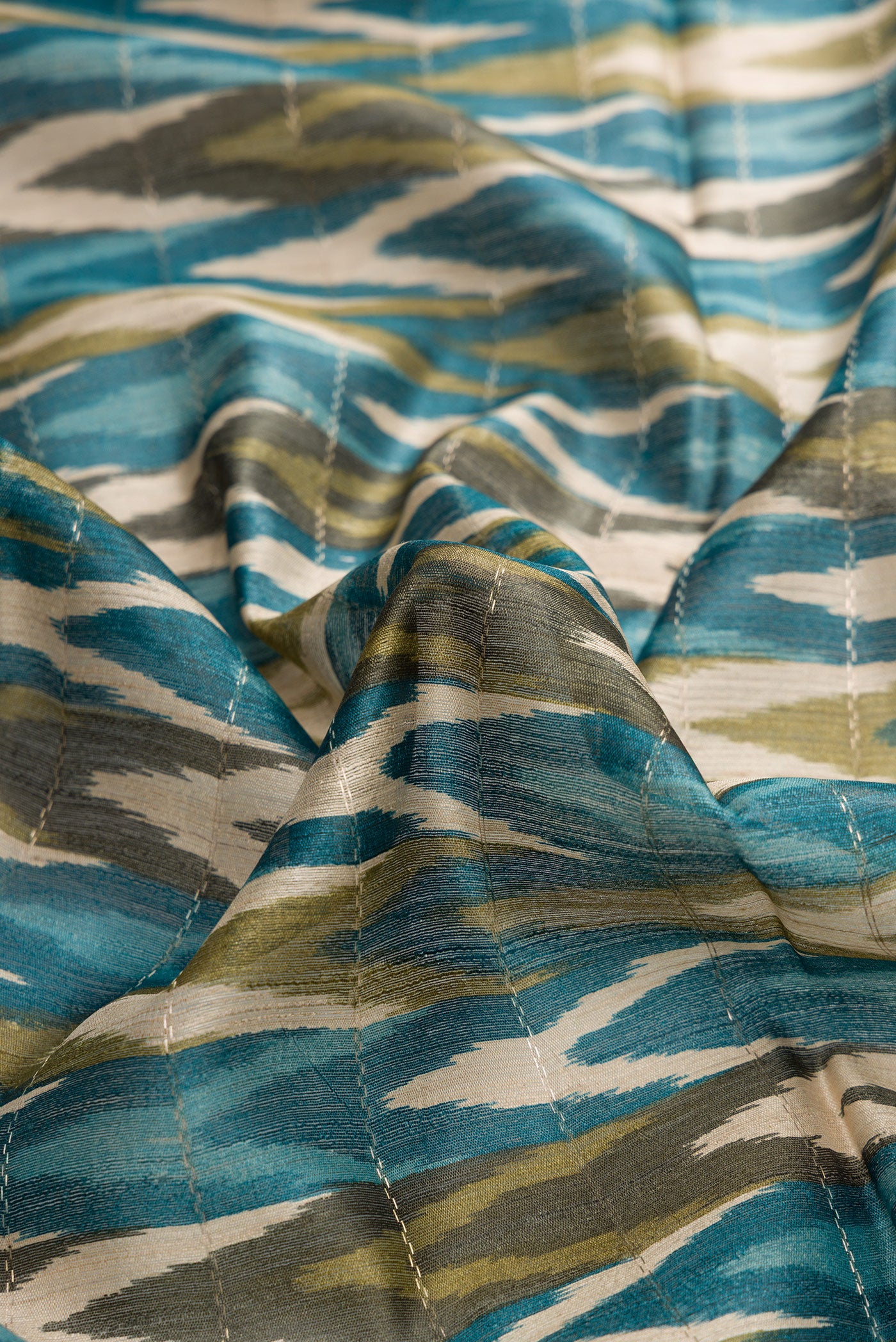 Close up of Sky Blue and Mehandi Green Color Tussar Silk Saree with Ikat Print on the body and Zari Border.  displaying folds
