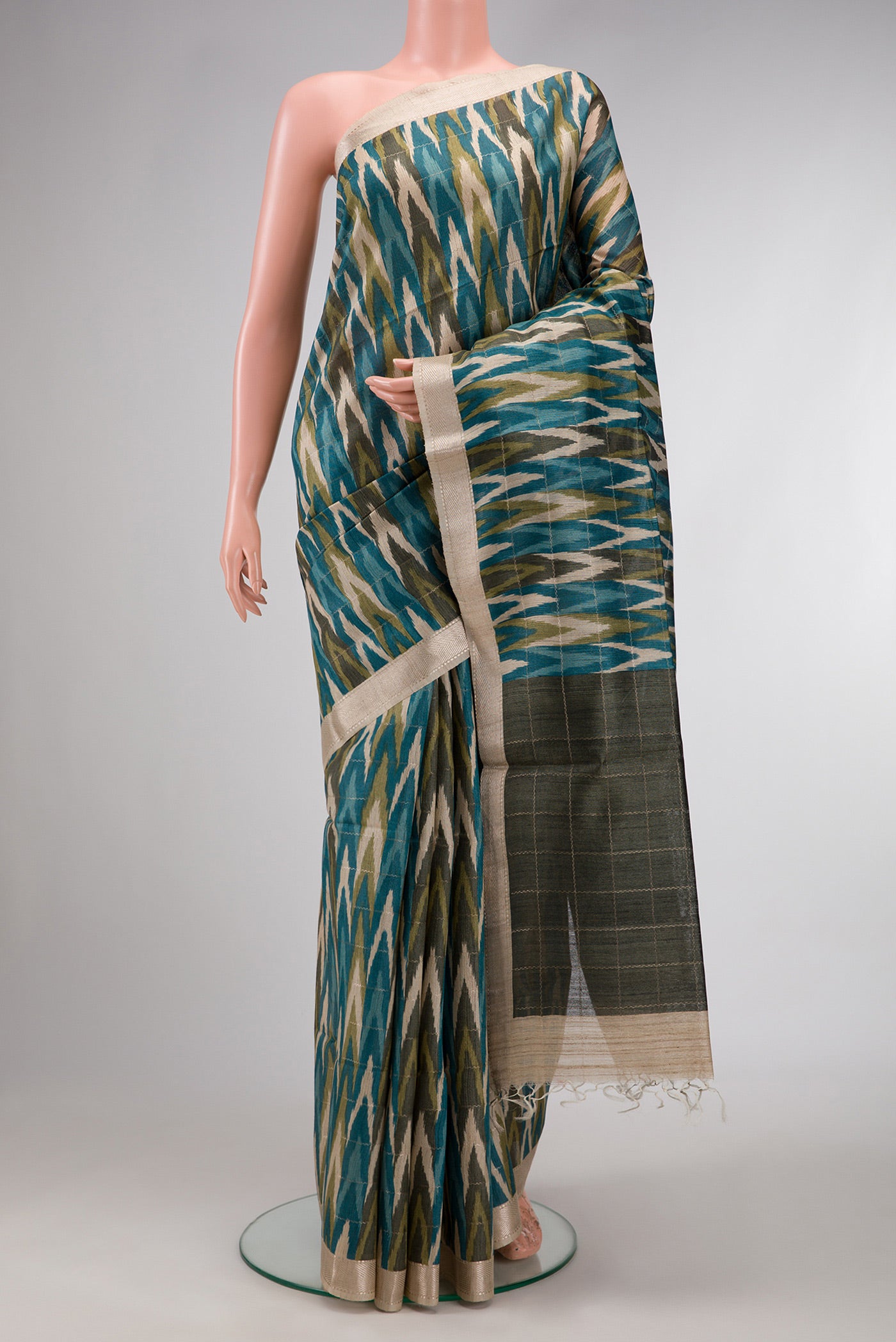 Sky Blue and Mehandi Green Color Tussar Silk Saree with Ikat Print on the body and Zari Border.  displayed on a mannequin