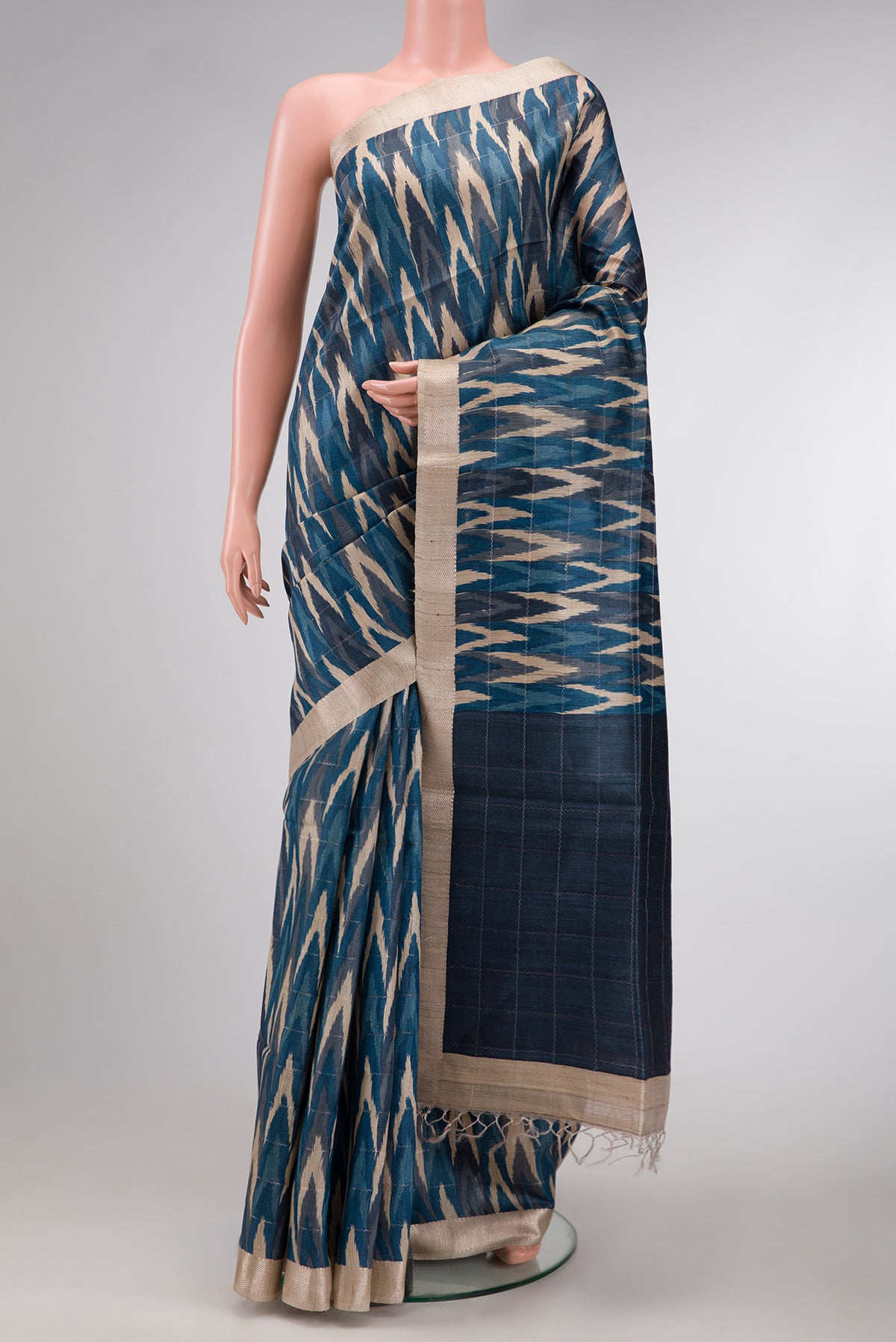 Peacock Blue and Beige Color Tussar Silk Saree with Ikat Print on the body and Zari Border.  displayed on a mannequin