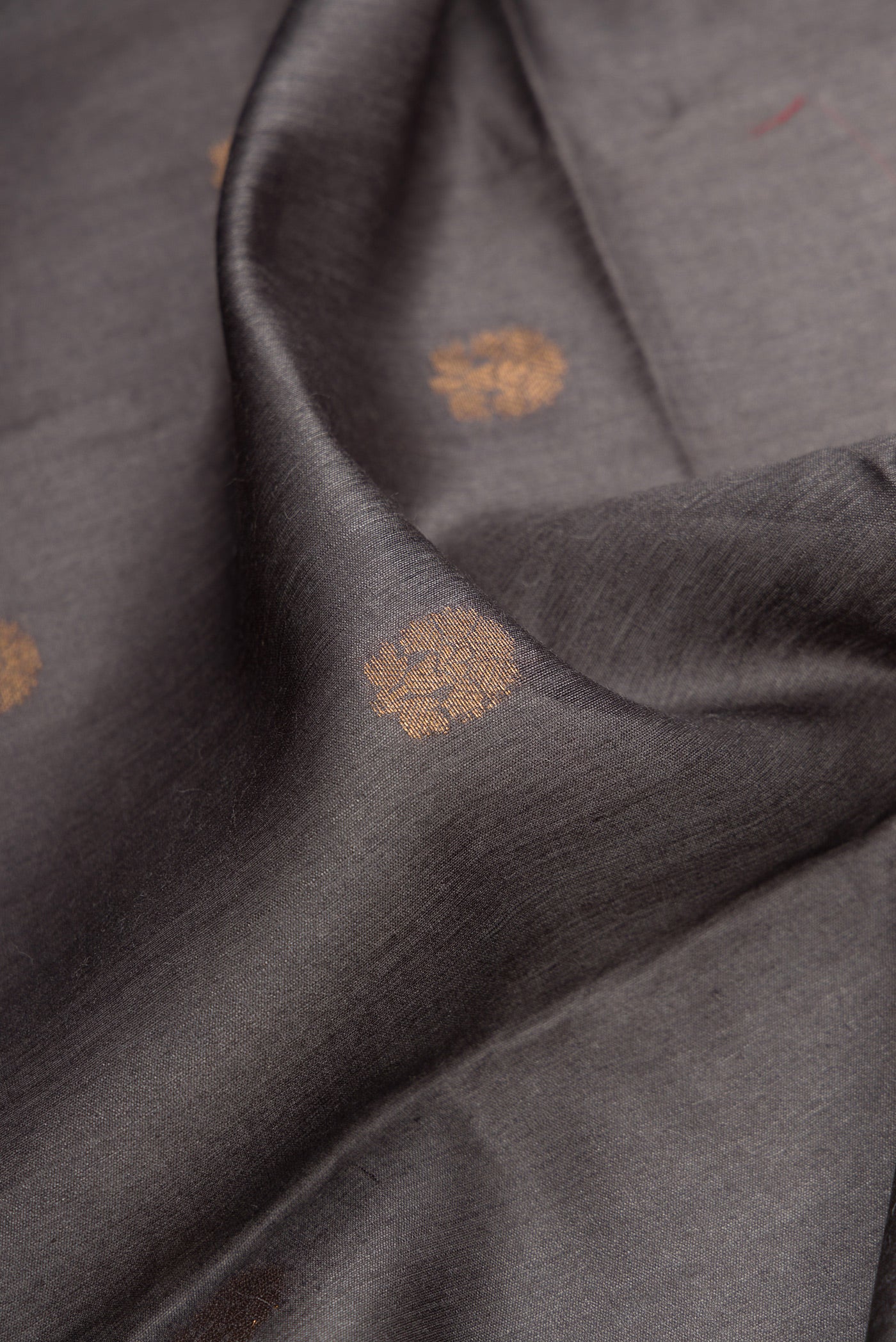Close up of Grey Dual Tone Tussar Silk Saree with Zari Butta on the body and Fancy Border.  displaying folds