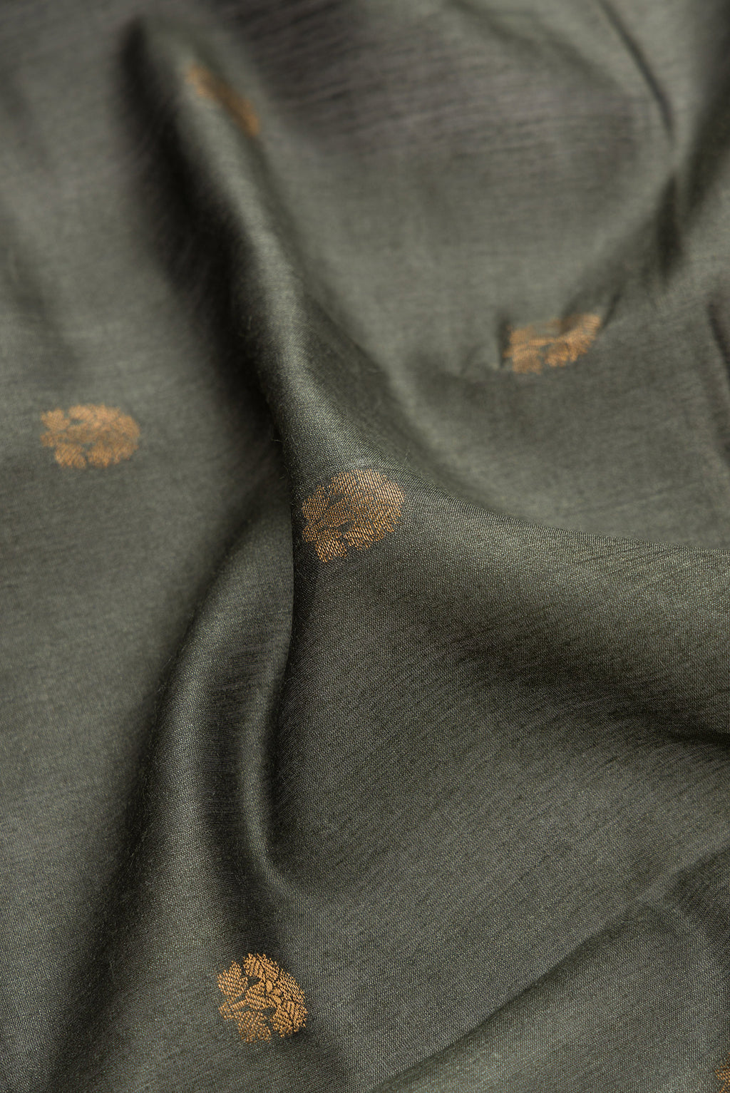 Close up of Green Dual Tone Tussar Silk Saree with Zari Butta on the body and Fancy Border.  displaying folds