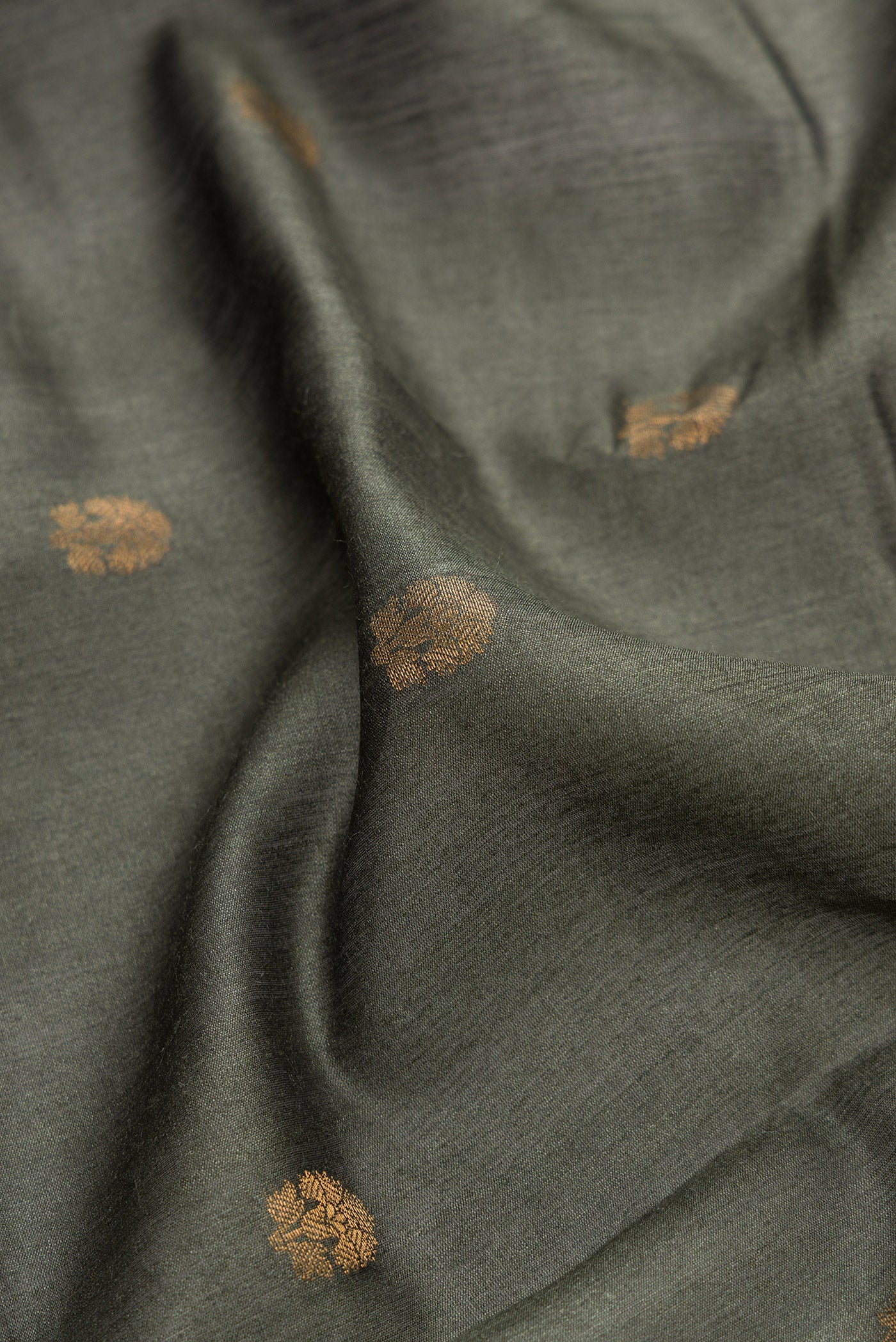 Close up of Green Dual Tone Tussar Silk Saree with Zari Butta on the body and Fancy Border.  displaying folds
