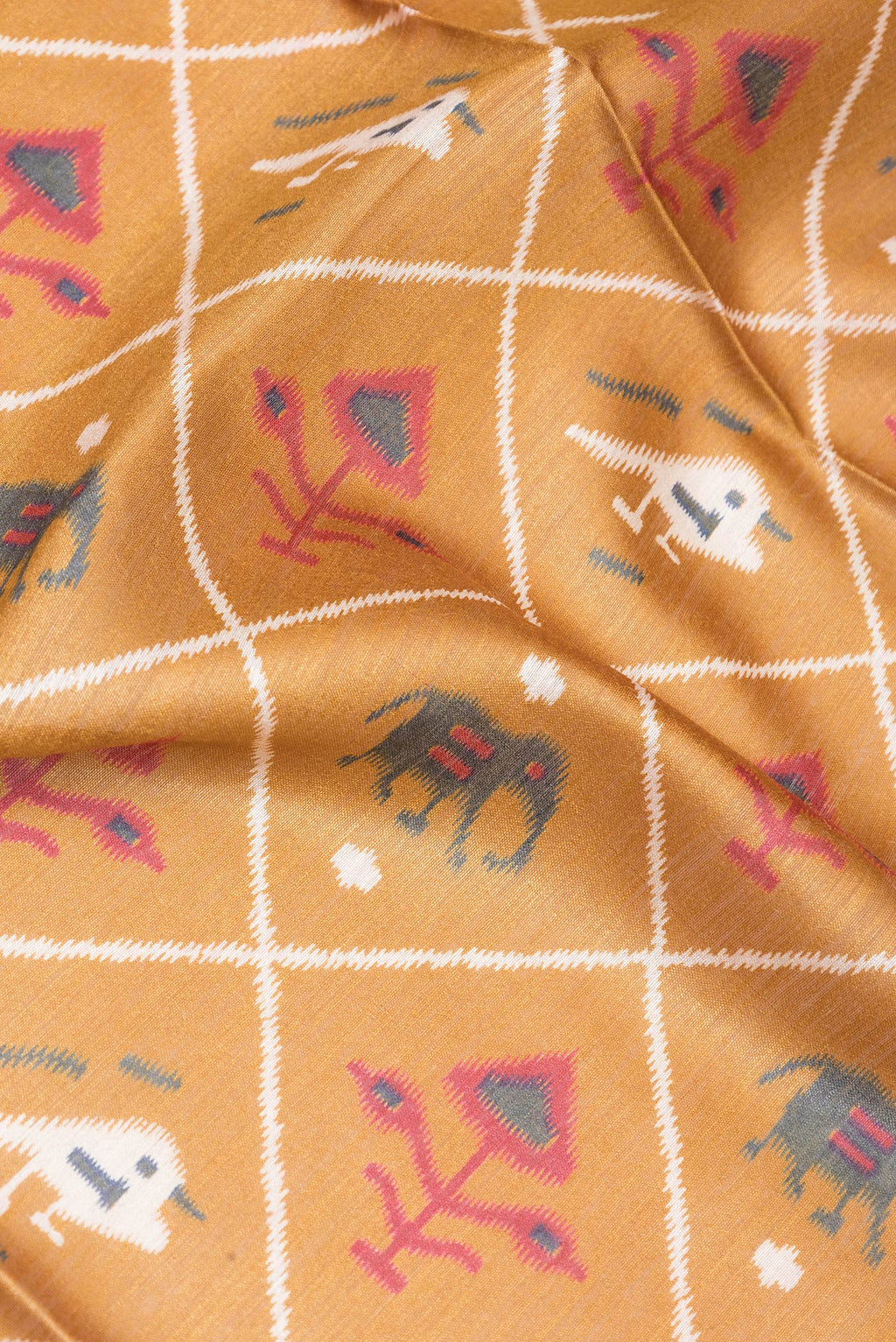 Close up of Gold Tussar Silk Saree with Ikat Print on the body and Zari Border.  displaying folds