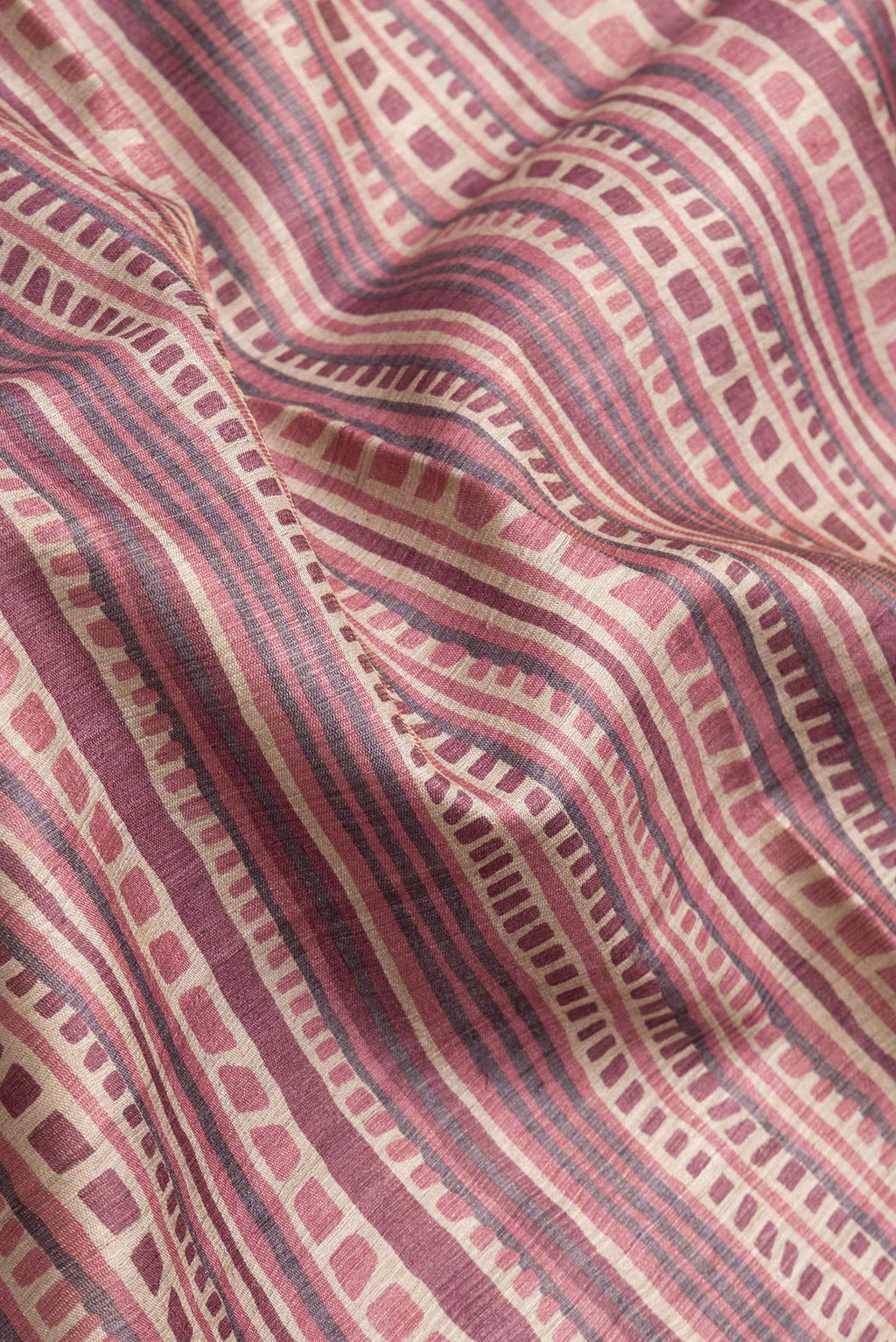 Close up of Beige Dual Tone Tussar Silk Saree with Printed design on the body and Printed Border.  displaying folds