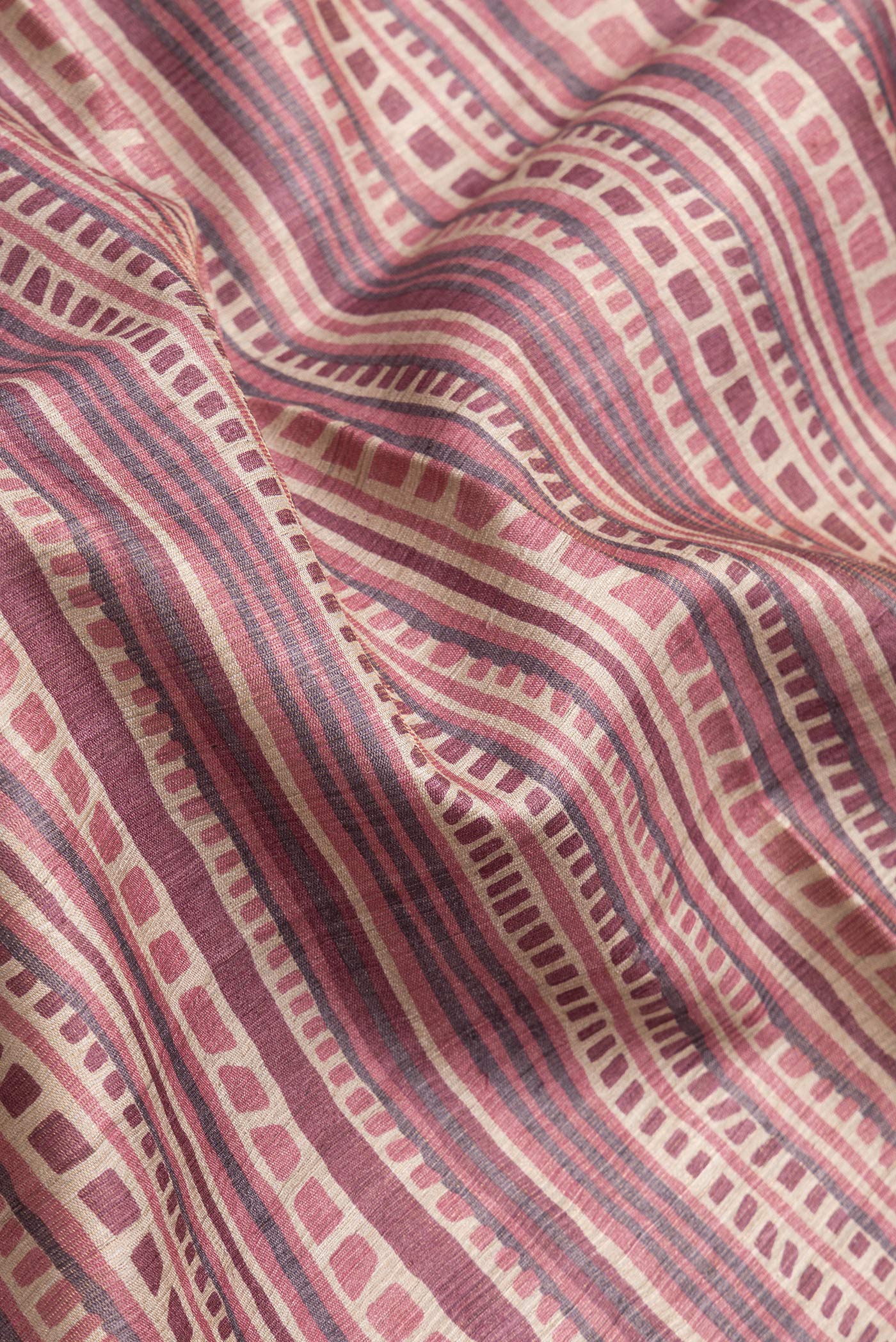 Close up of Beige Dual Tone Tussar Silk Saree with Printed design on the body and Printed Border.  displaying folds