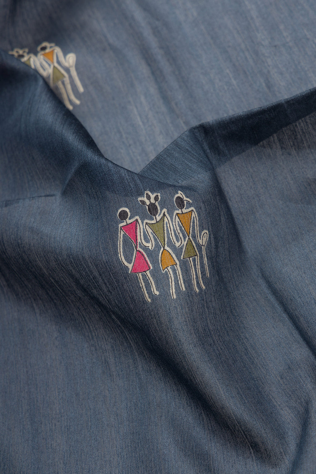 Close up of Grey Dual Tone Tussar Silk Saree with Printed design on the body and Ikat Border.  displaying folds