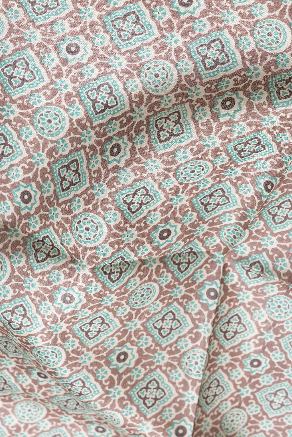 Close up of Brown Dual Tone Tussar Silk Saree with Printed design on the body and Zari Border.  displaying folds