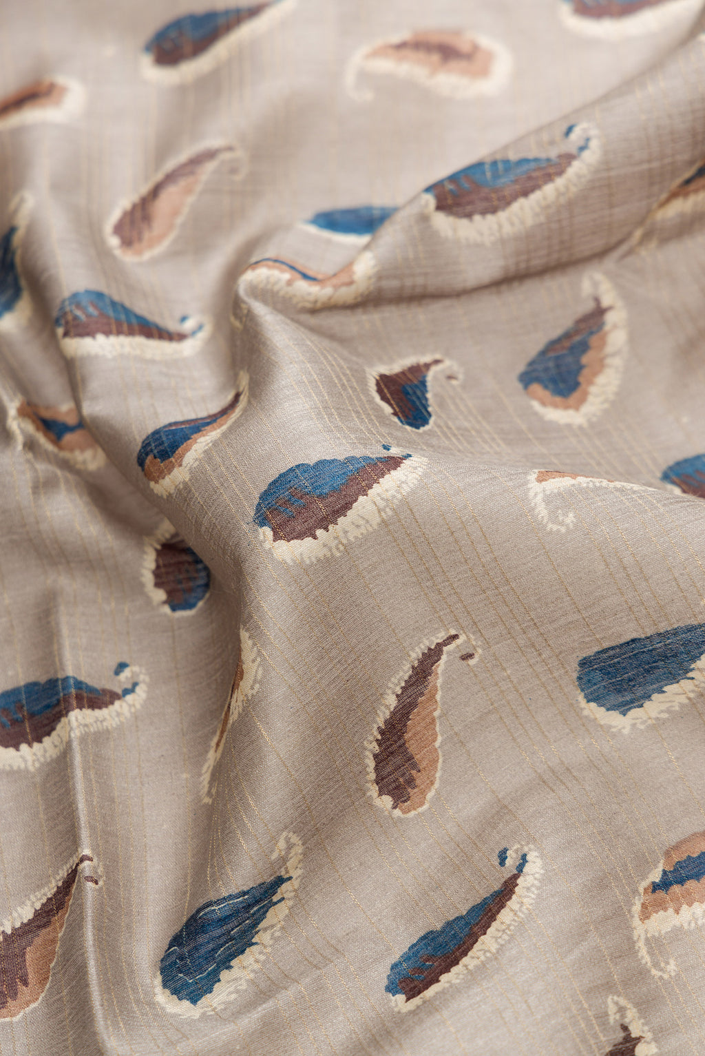 Close up of Grey Dual Tone Tussar Silk Saree with Printed design on the body and Zari Border.  displaying folds