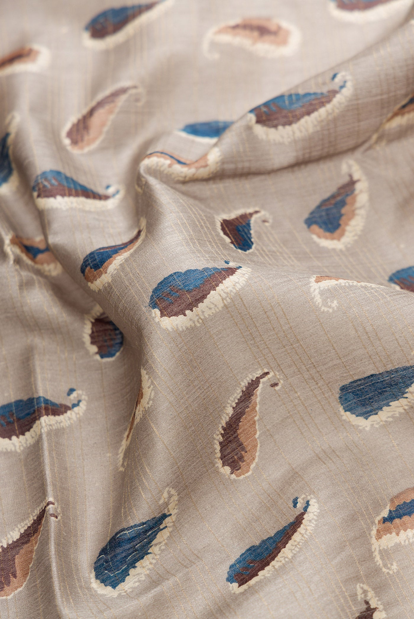 Close up of Grey Dual Tone Tussar Silk Saree with Printed design on the body and Zari Border.  displaying folds
