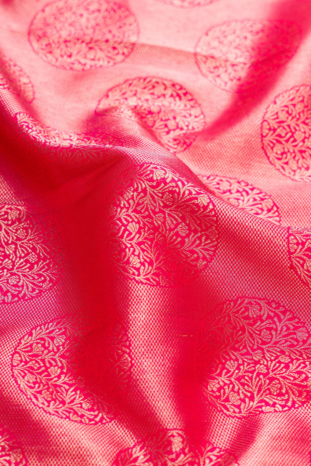 Close up of Pink Dual Tone Kanchipuram Silk Saree with Zari Butta on the body and Zari Border.  displaying folds