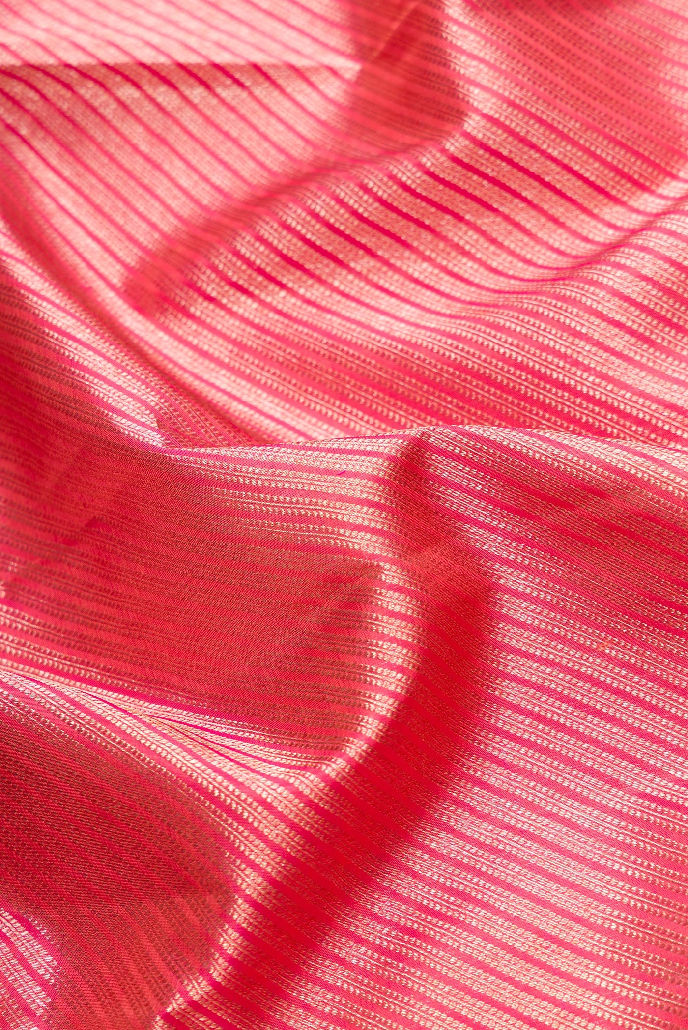 Close up of Orange Dual Tone Kanchipuram Silk Saree with Zari Brocade on the body and Zari Border.  displaying folds