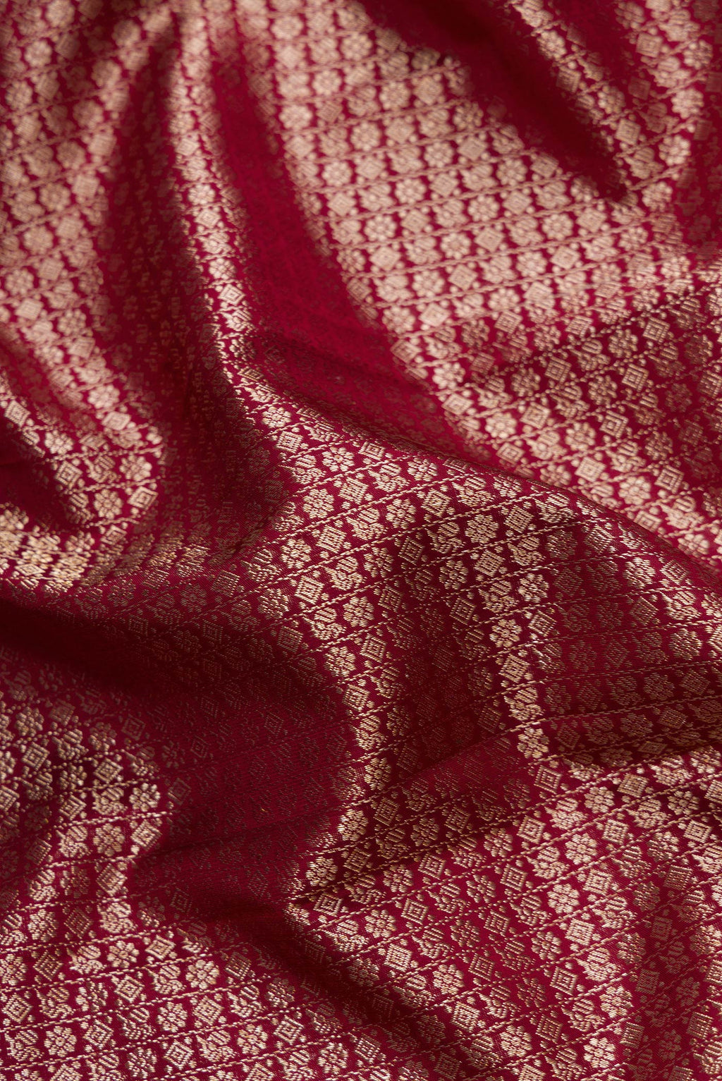 Close up of Maroon Dual Tone Kanchipuram Silk Saree with Zari Brocade on the body and Zari Border.  displaying folds