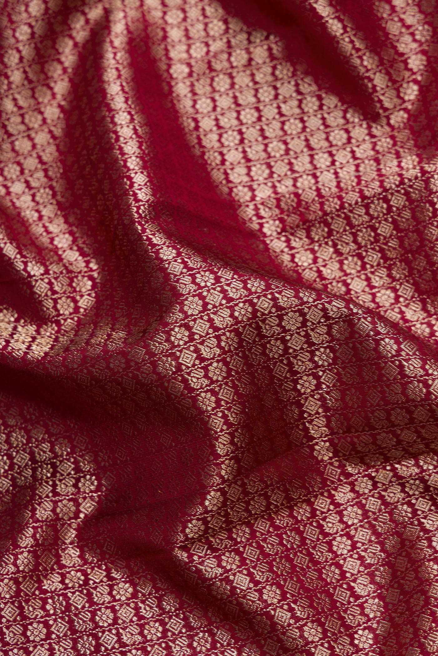 Close up of Maroon Dual Tone Kanchipuram Silk Saree with Zari Brocade on the body and Zari Border.  displaying folds