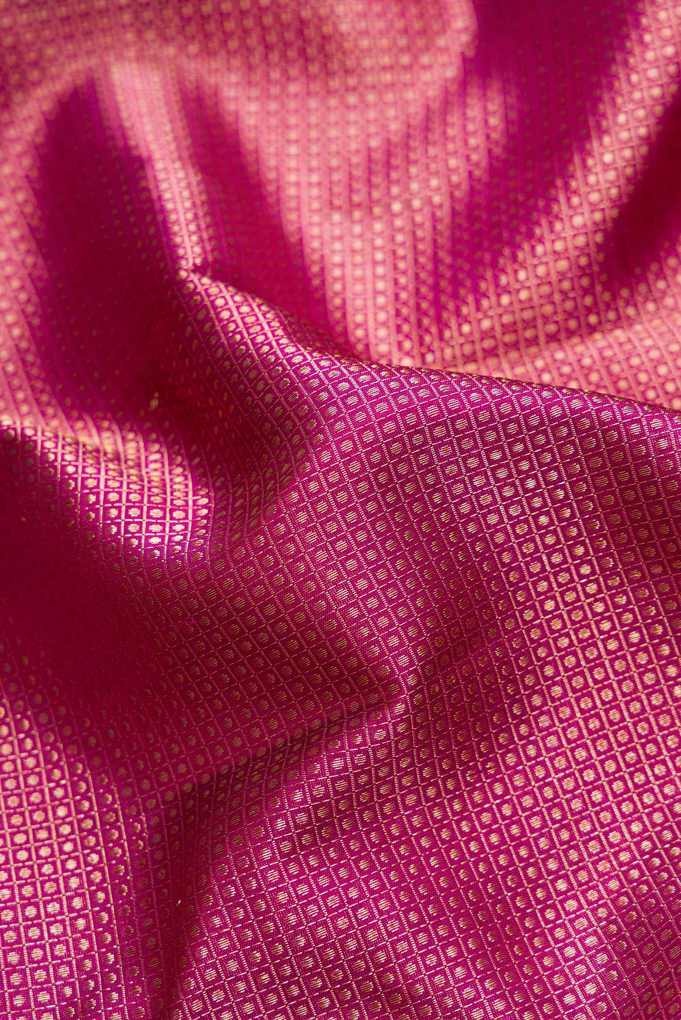 Close up of Magenta Dual Tone Kanchipuram Silk Saree with Zari Brocade on the body and Fancy Border.  displaying folds