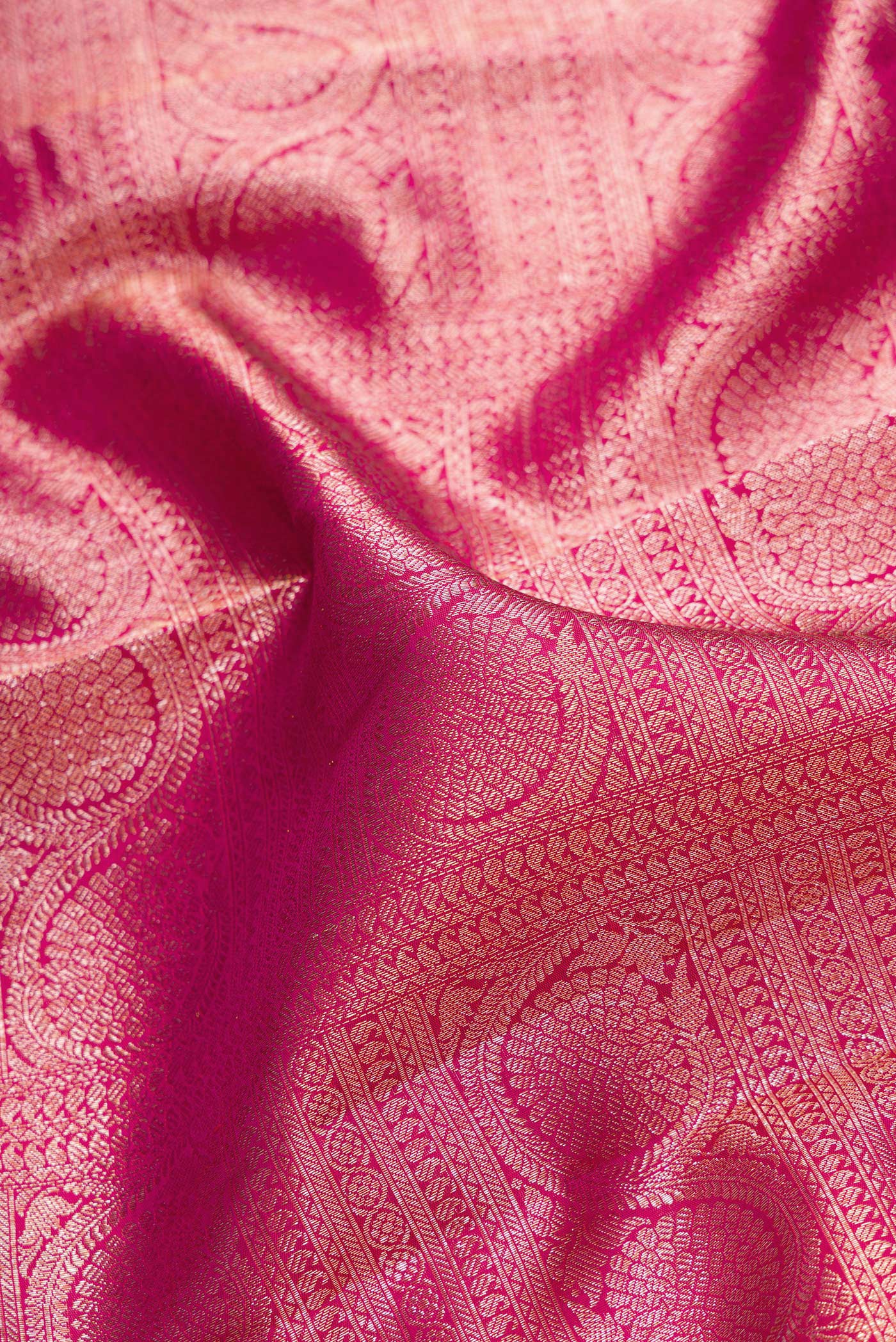 Close up of Pink Dual Tone Kanchipuram Silk Saree with Zari Brocade on the body and Zari Border.  displaying folds