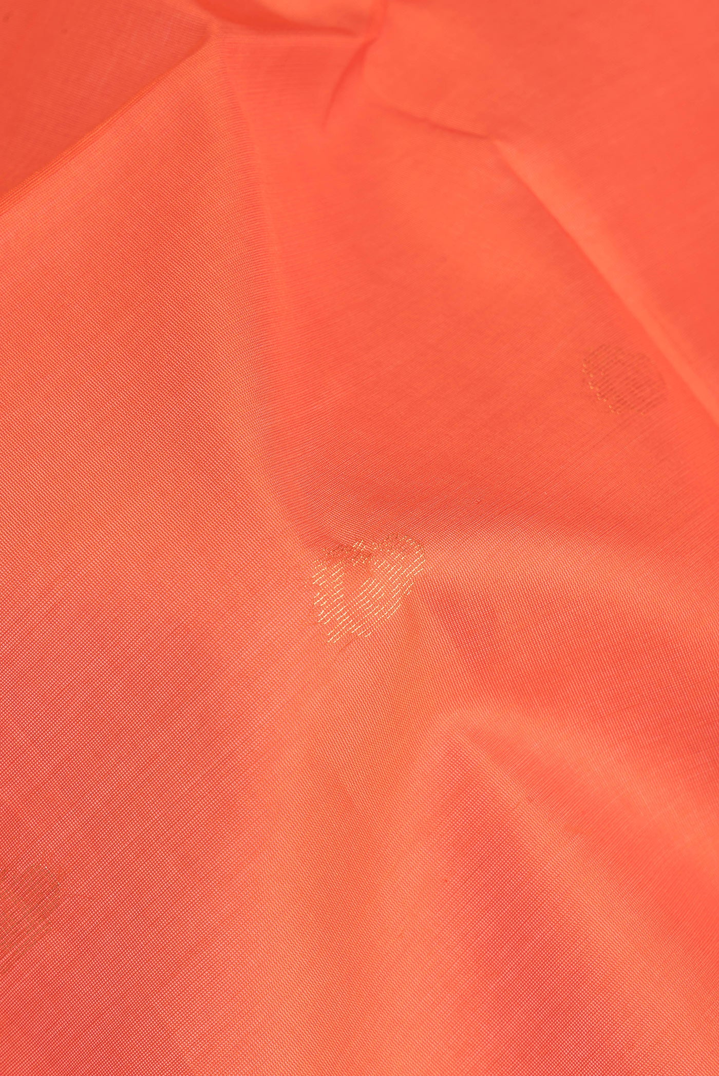 Close up of Orange Silk Cotton Saree with Zari Butta on the body and Zari Border.  displaying folds