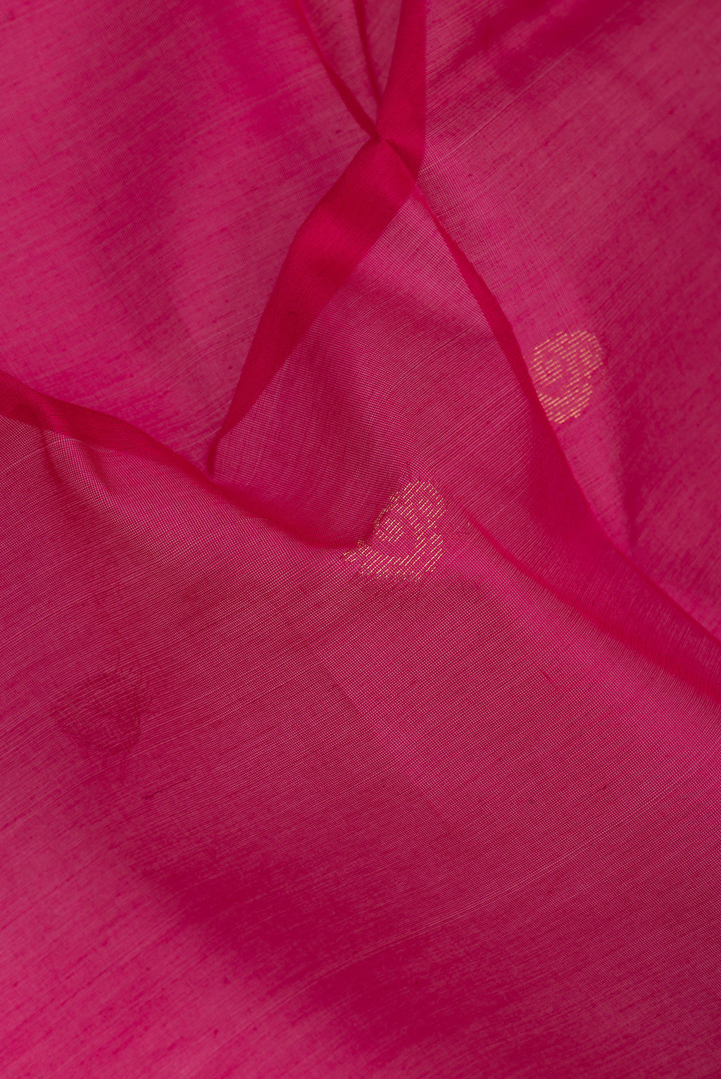 Close up of Dark Pink Silk Cotton Saree with Zari Butta on the body and Zari Border.  displaying folds
