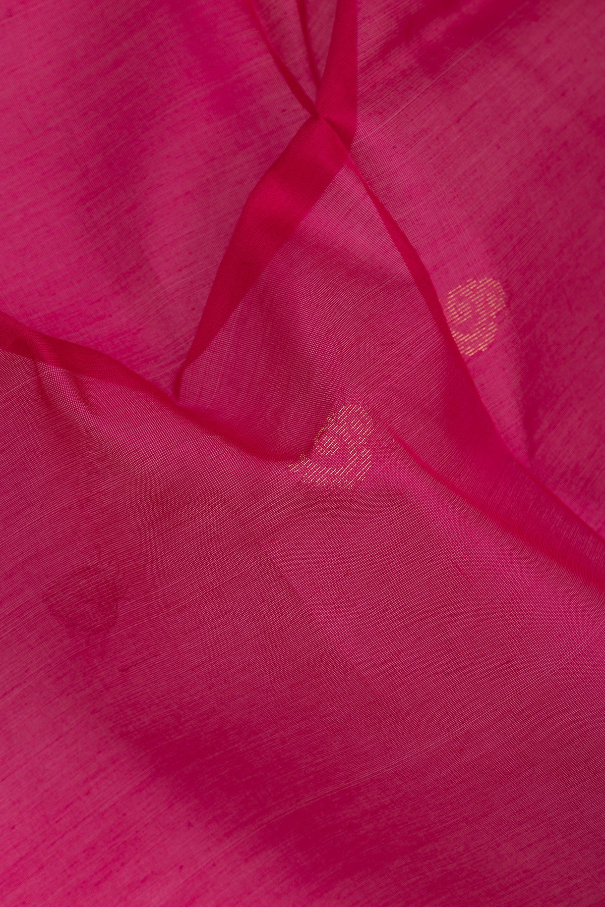 Close up of Dark Pink Silk Cotton Saree with Zari Butta on the body and Zari Border.  displaying folds