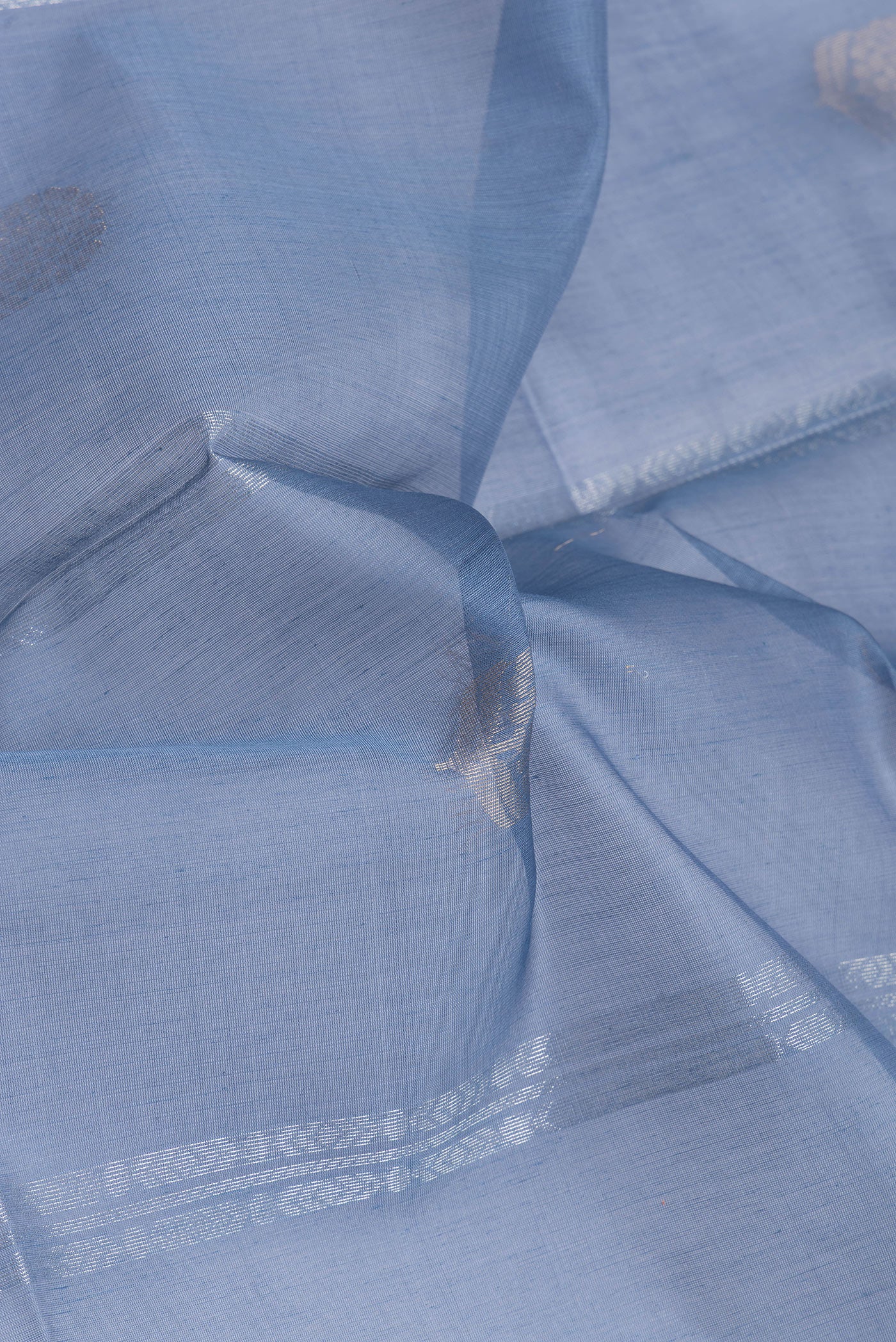 Close up of Blue Silk Cotton Saree with Zari Butta on the body and Zari Border.  displaying folds