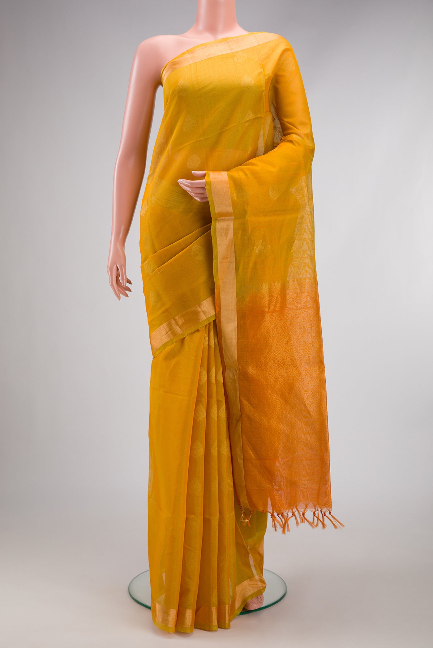 Mustard Silk Cotton Saree with Zari Butta on the body and Zari Border.  displayed on a mannequin