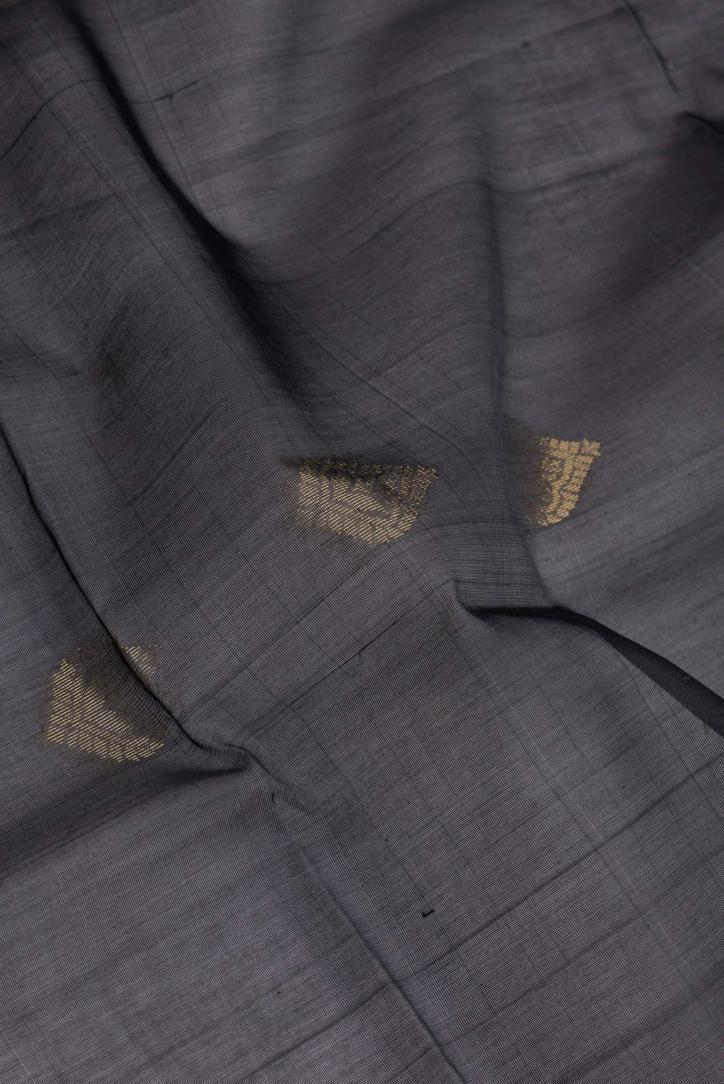 Close up of Black Silk Cotton Saree with Zari Butta on the body and Zari Border.  displaying folds