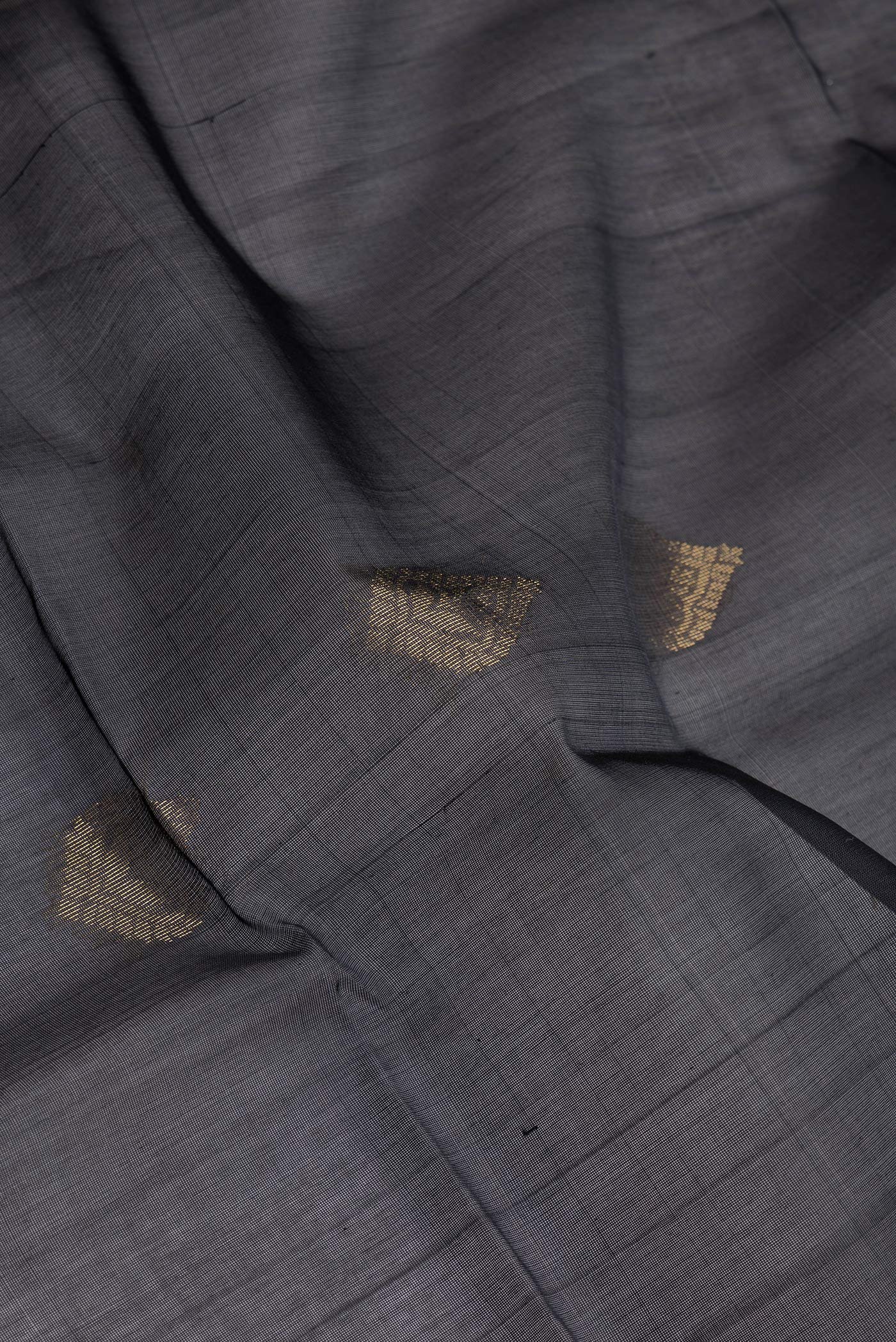 Close up of Black Silk Cotton Saree with Zari Butta on the body and Zari Border.  displaying folds