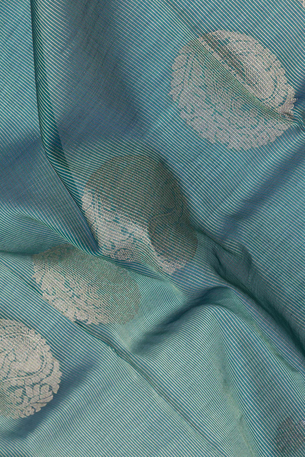 Close up of Peacock Blue Dual Tone Silk Cotton Saree with Zari Butta on the body and Zari Border.  displaying folds