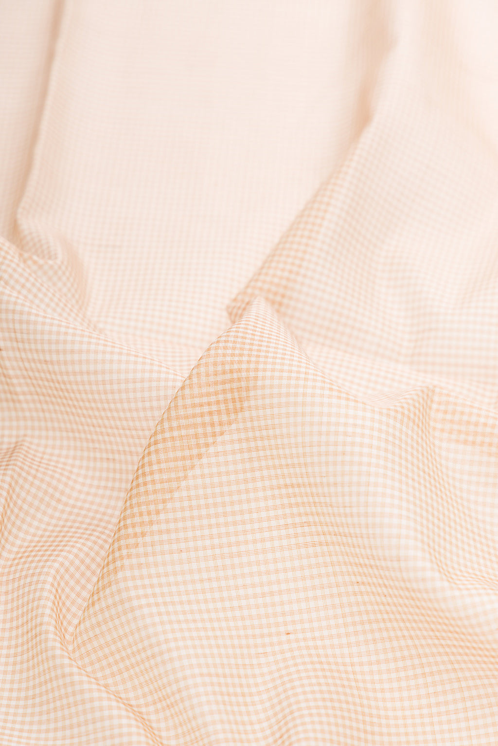 Close up of Beige Dual Tone Maheshwari Silk Saree with Checked design on the body and Zari Border.  displaying folds