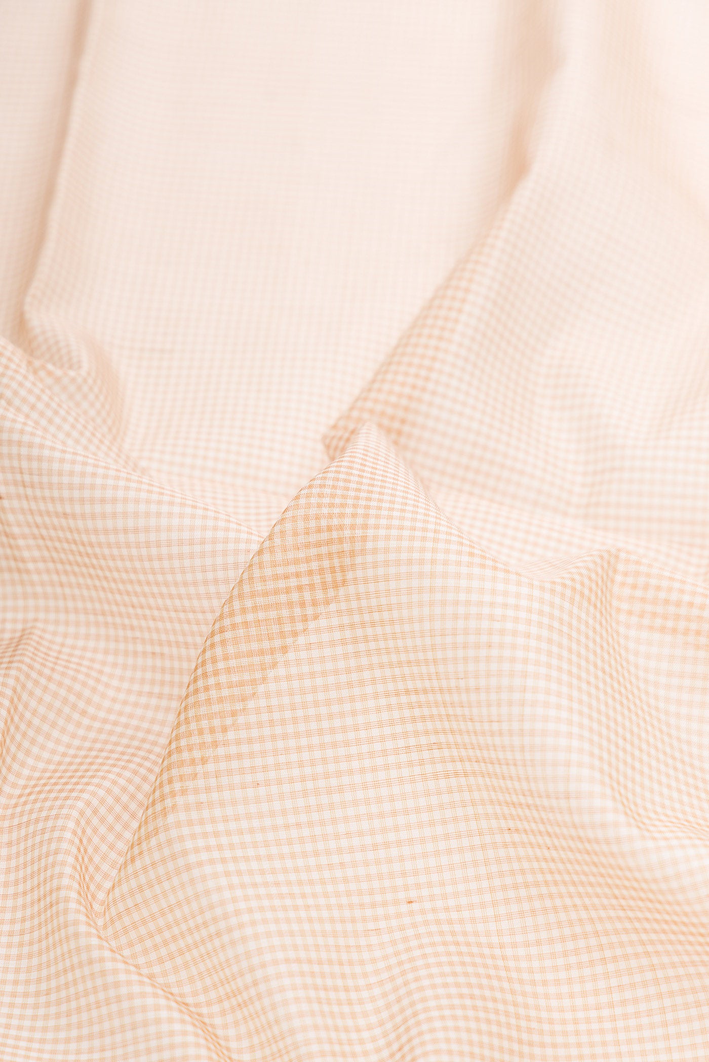 Close up of Beige Dual Tone Maheshwari Silk Saree with Checked design on the body and Zari Border.  displaying folds