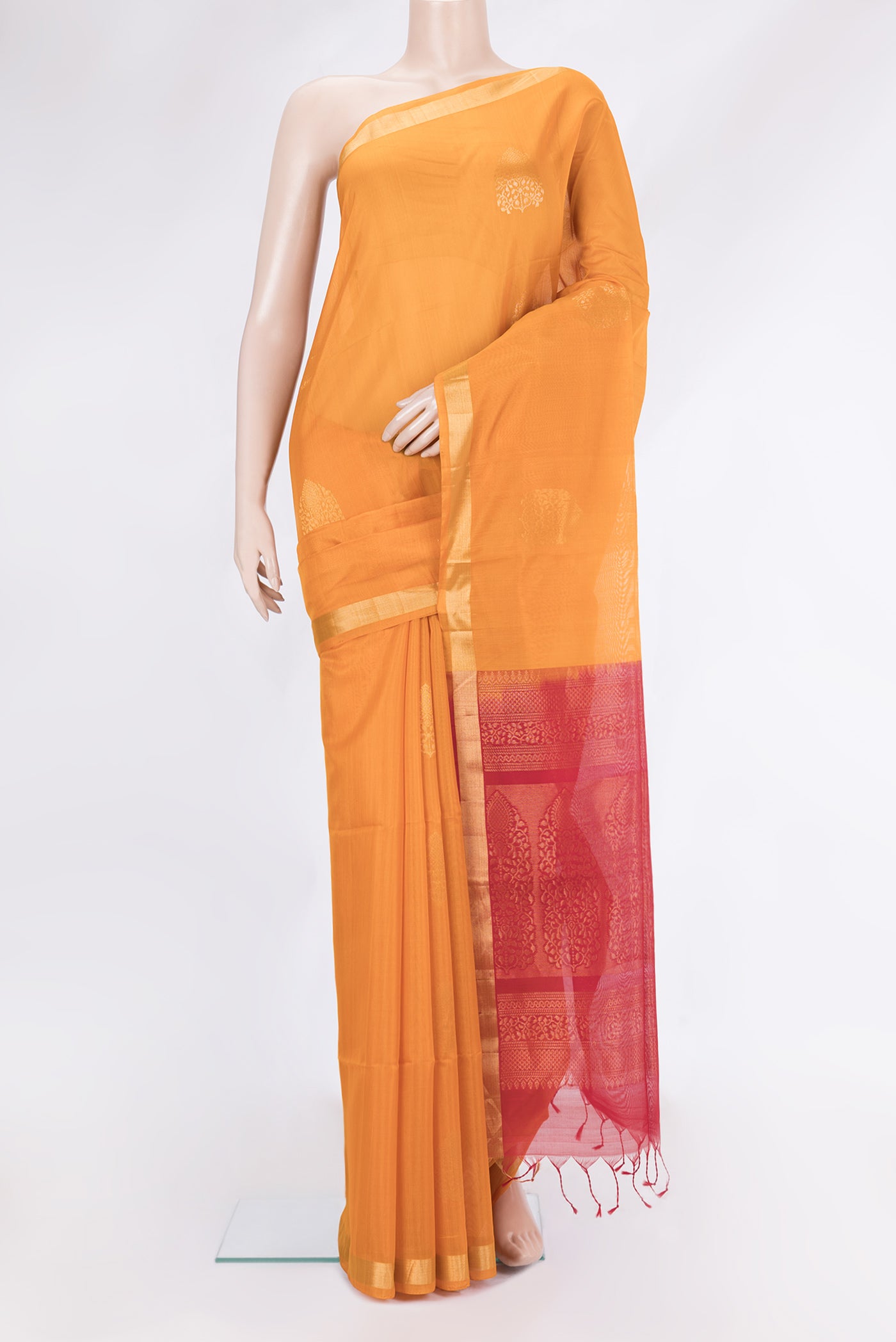 Orange Silk Cotton Saree with Zari Butta on the body and Zari Border.  displayed on a mannequin