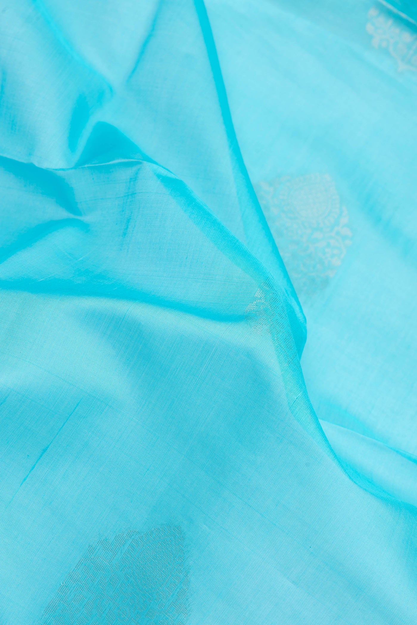 Close up of Sky Blue Banarasi Silk Cotton Saree with Zari Butta on the body and Zari Border.  displaying folds