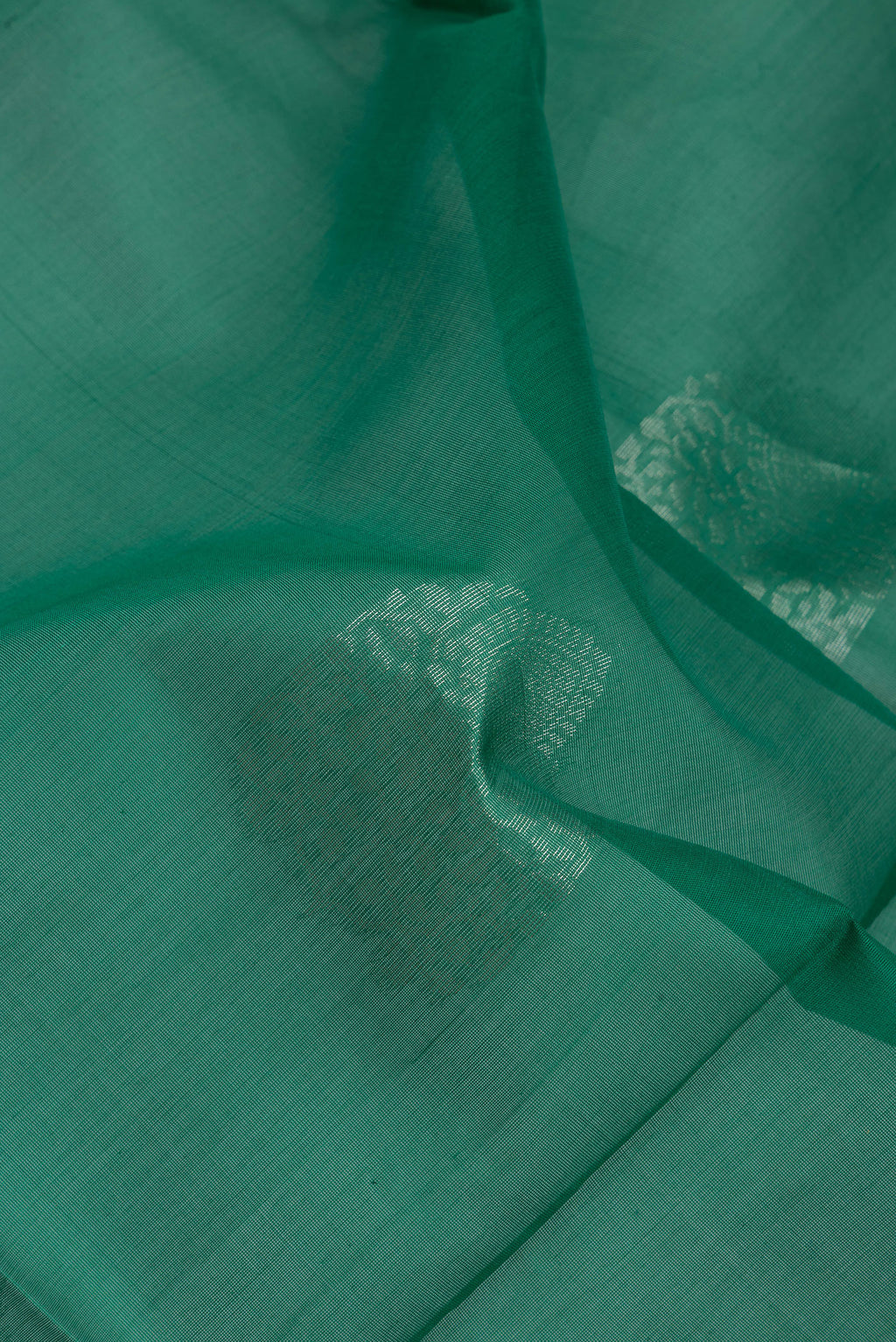 Close up of Bottle Green Silk Cotton Saree with Zari Butta on the body and Zari Border.  displaying folds
