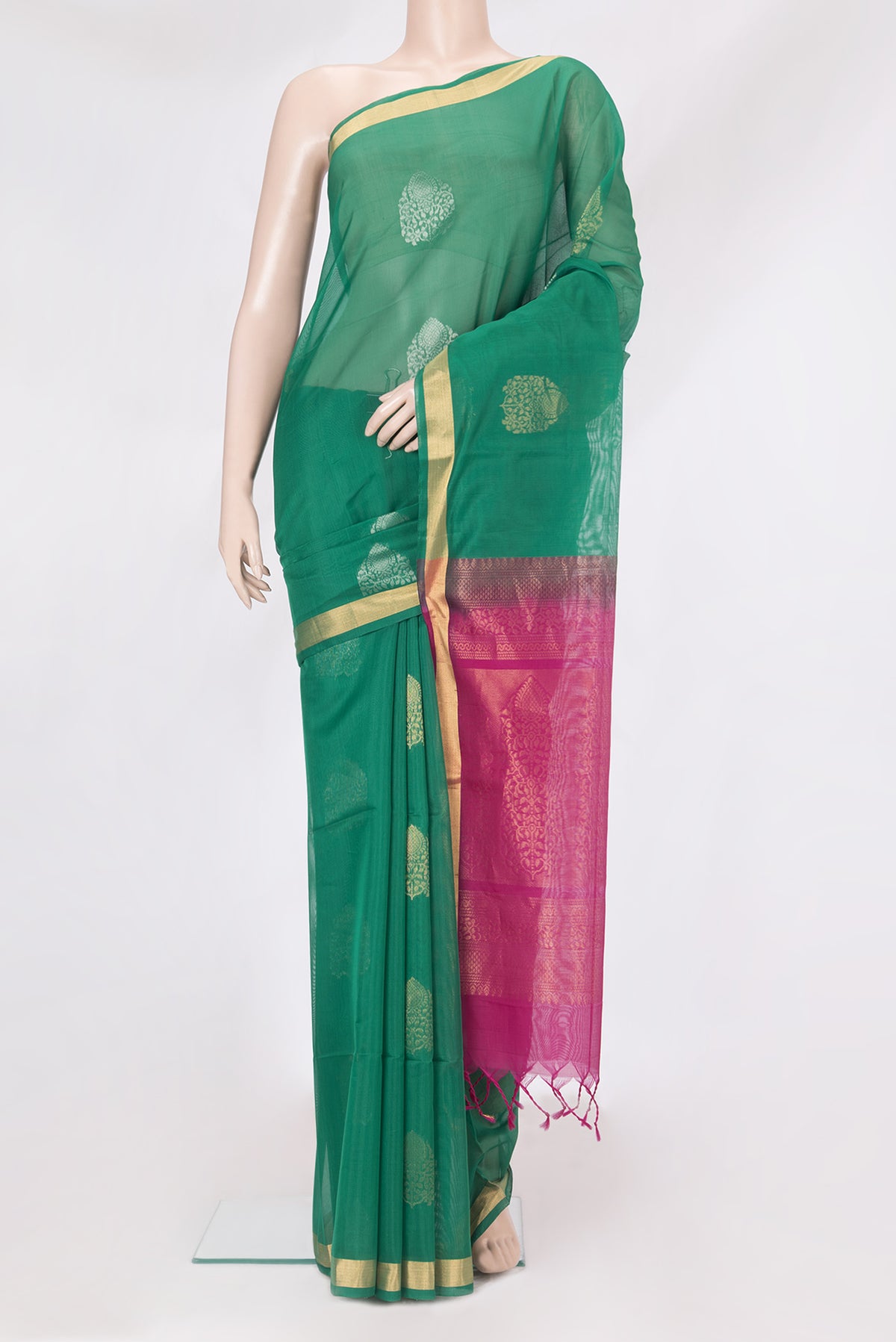 Bottle Green Silk Cotton Saree with Zari Butta on the body and Zari Border.  displayed on a mannequin