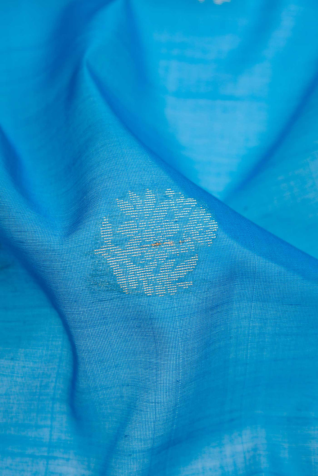 Close up of Sky Blue Dual Tone Silk Cotton Saree with Zari Butta on the body and Zari Border.  displaying folds