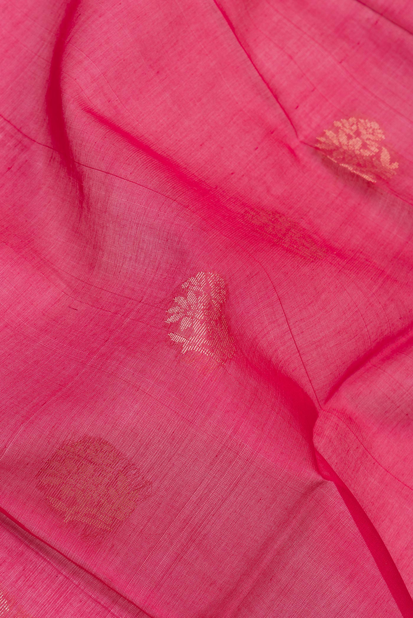 Close up of Dark Pink Silk Cotton Saree with Zari Butta on the body and Zari Border.  displaying folds