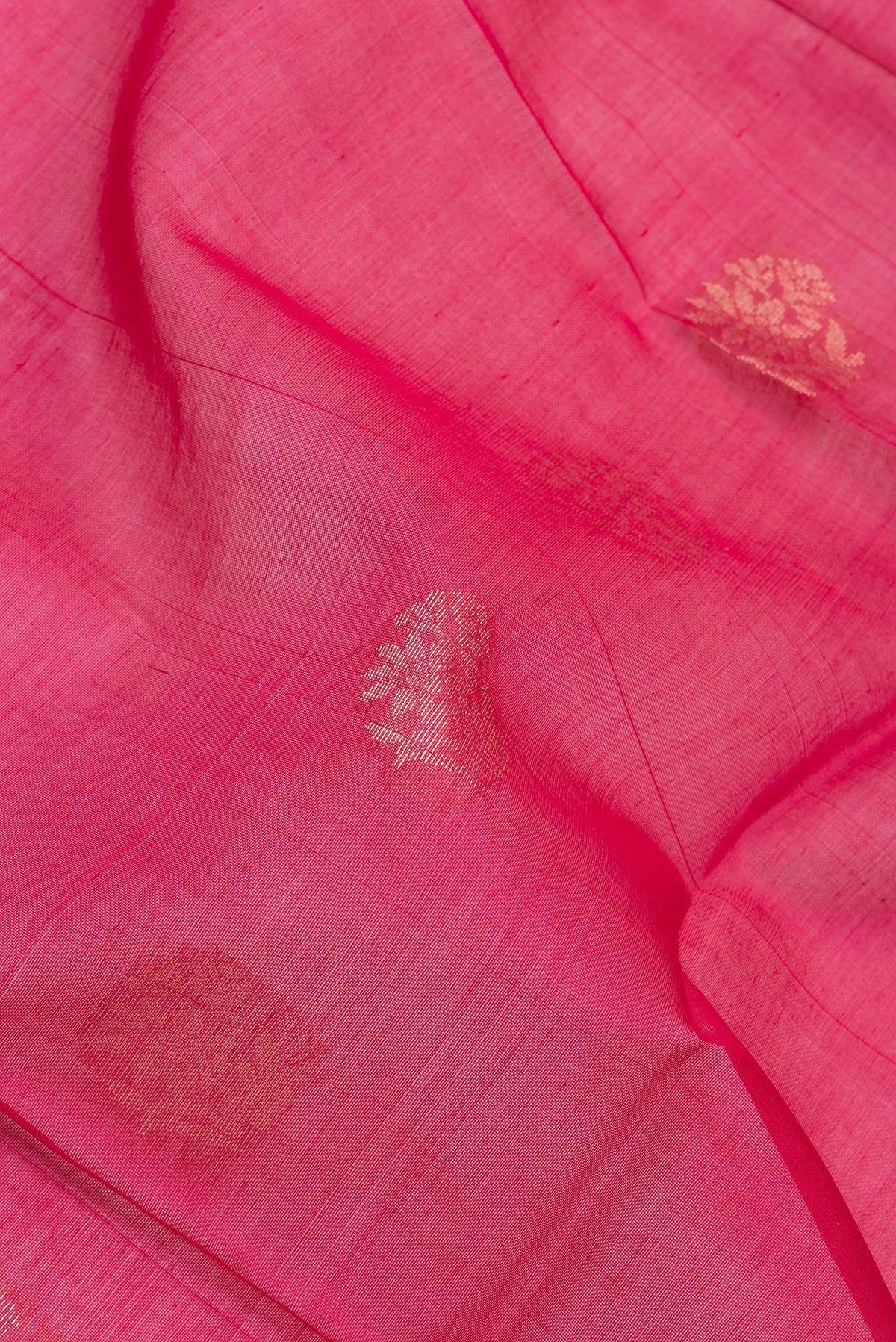 Close up of Dark Pink Silk Cotton Saree with Zari Butta on the body and Zari Border.  displaying folds