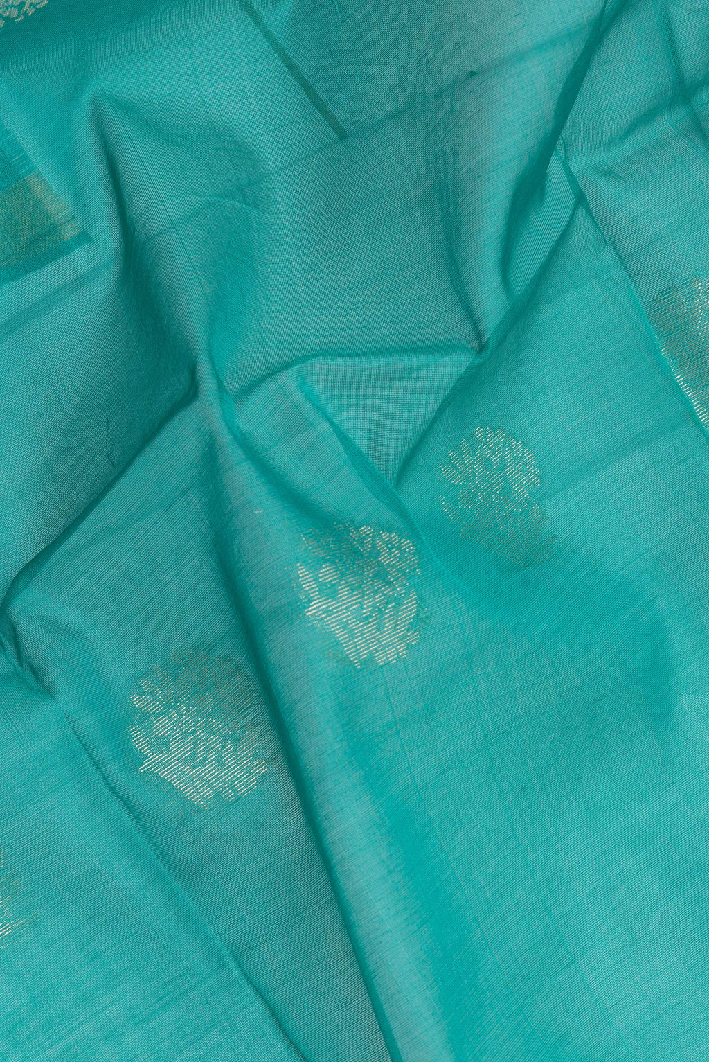 Close up of Green Silk Cotton Saree with Zari Butta on the body and Zari Border.  displaying folds
