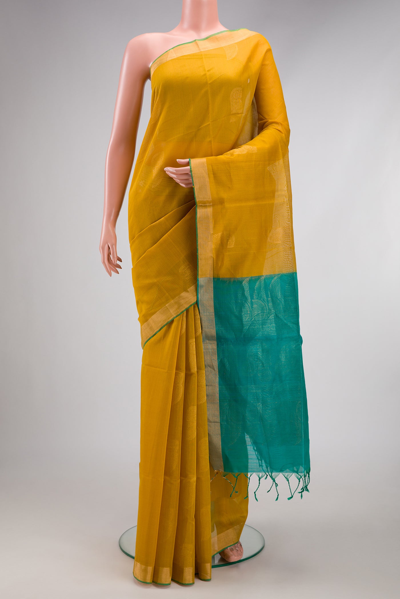 Mustard Silk Cotton Saree with Zari Butta on the body and Zari Border.  displayed on a mannequin