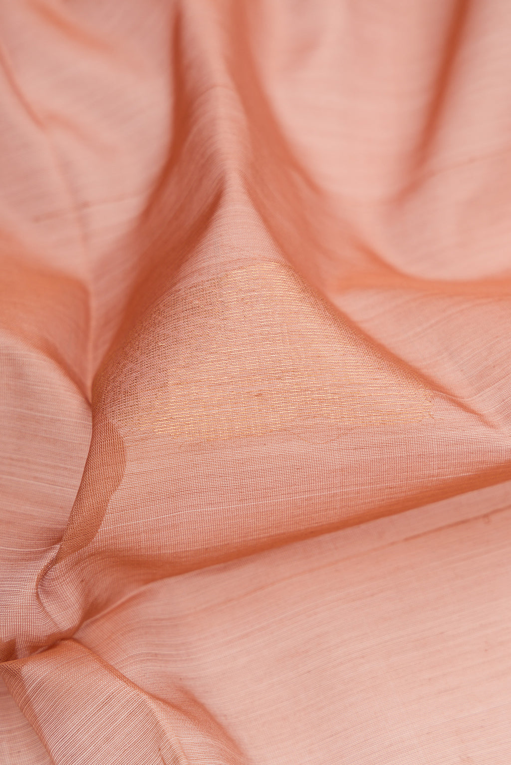 Close up of Rose Gold Silk Cotton Saree with Zari Butta on the body and Zari Border.  displaying folds