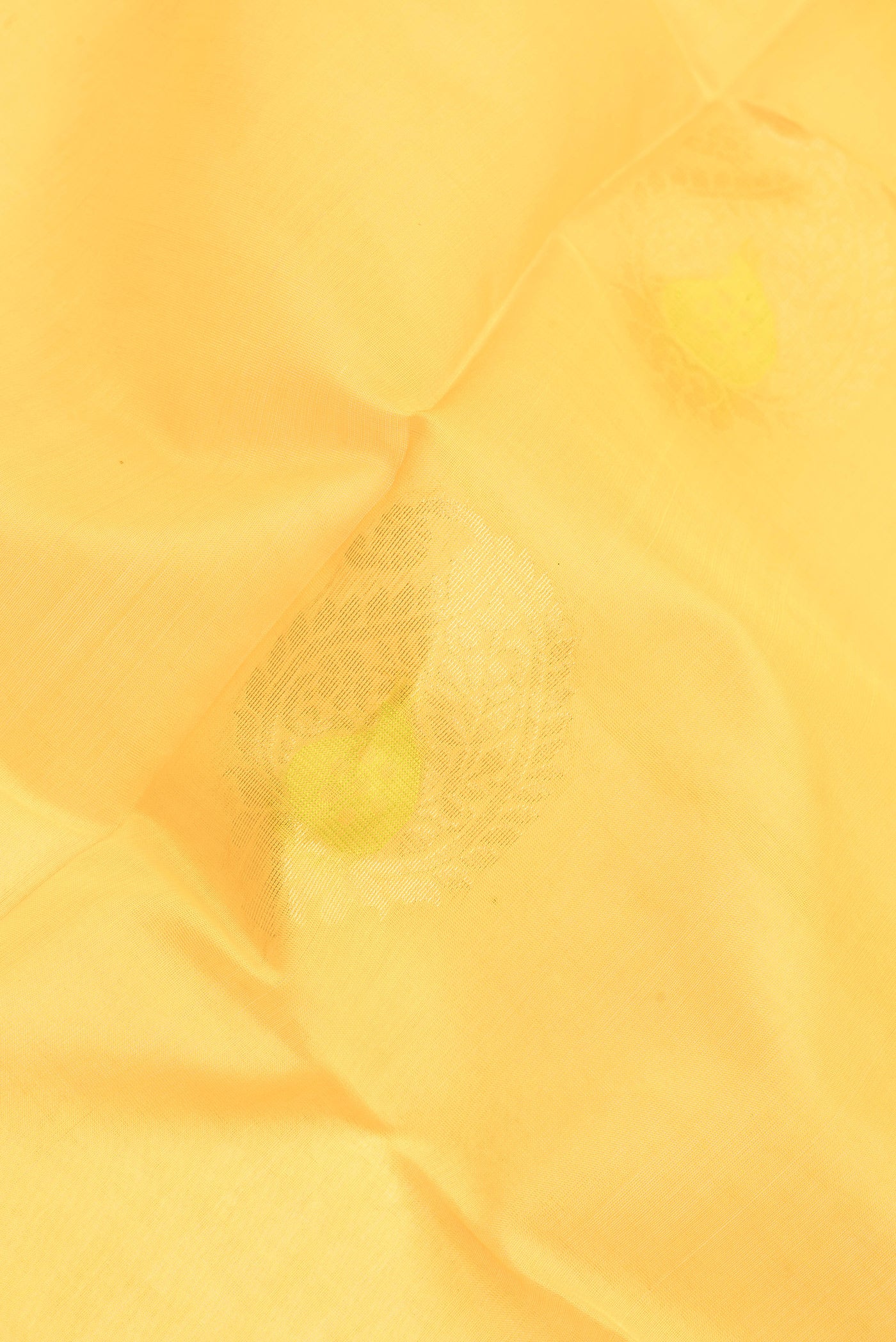 Close up of Yellow Silk Cotton Saree with Zari And Thread Butta on the body and Zari Border.  displaying folds