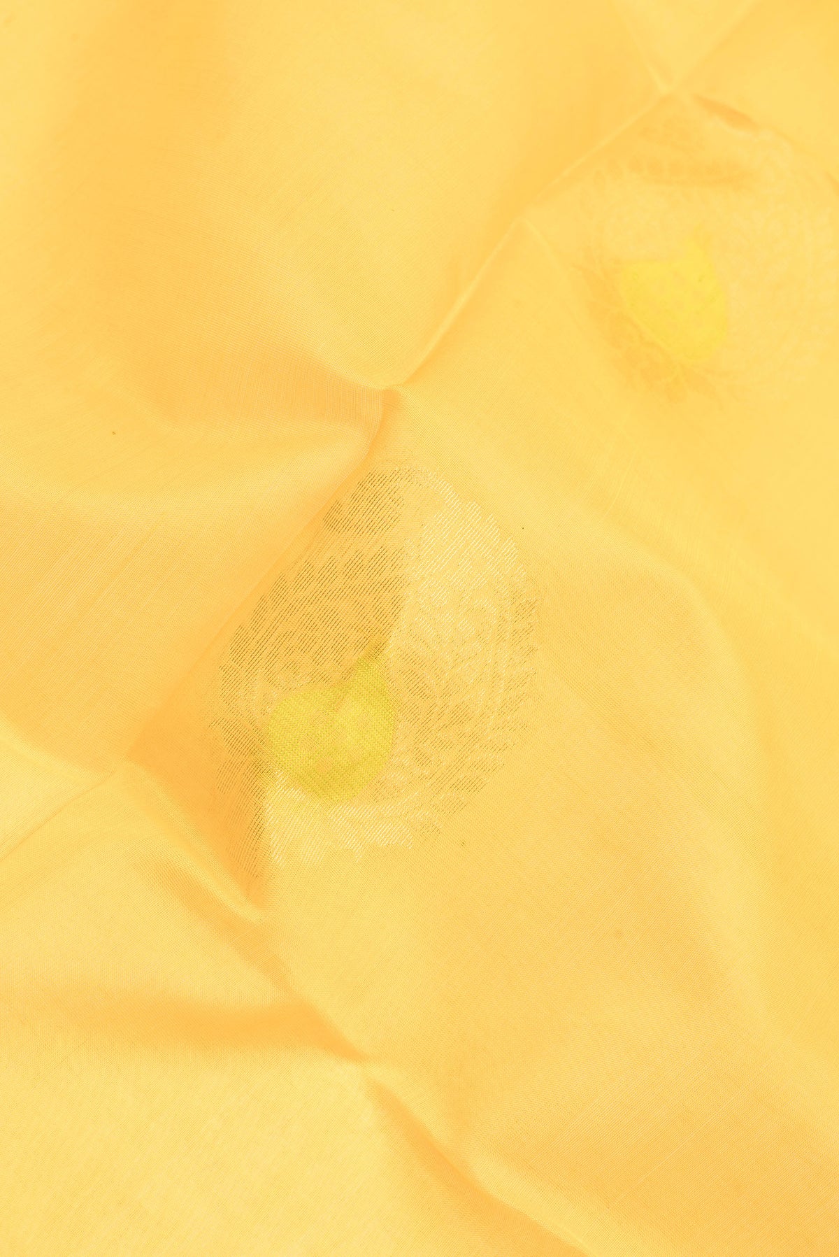 Close up of Yellow Silk Cotton Saree with Zari And Thread Butta on the body and Zari Border.  displaying folds