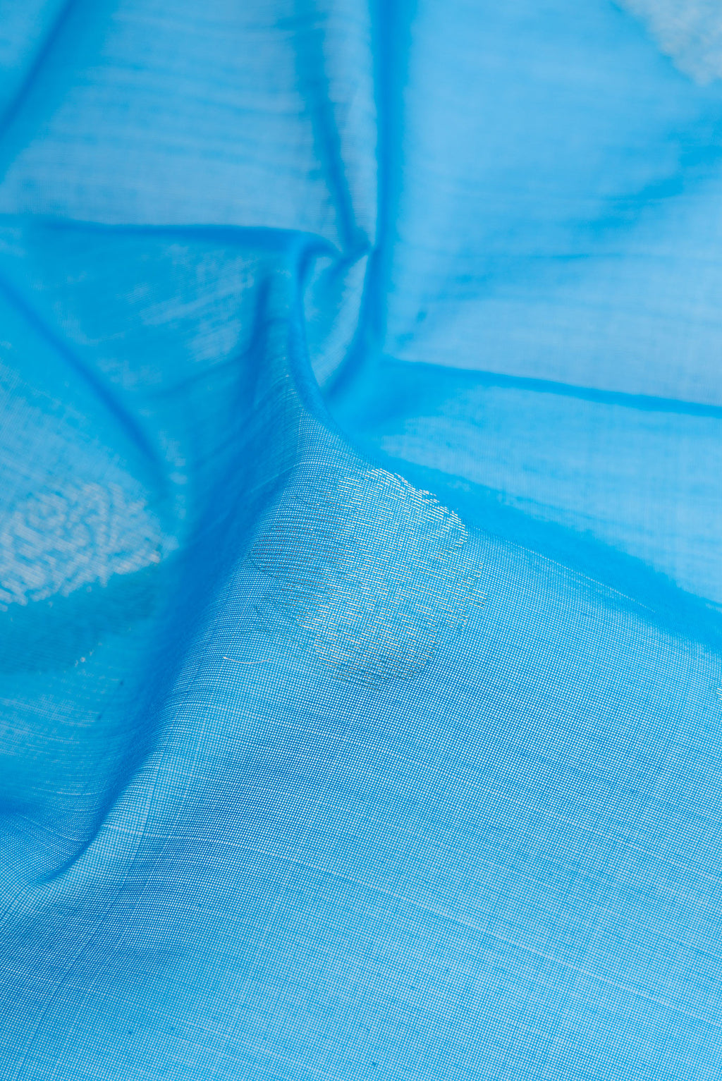 Close up of Sky Blue Silk Cotton Saree with Zari Butta on the body and Zari Border.  displaying folds