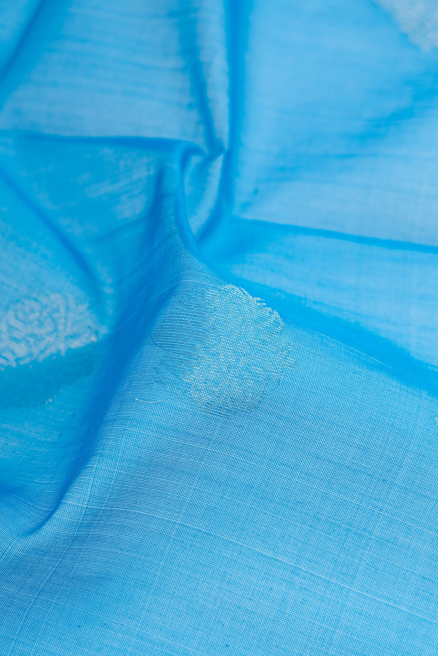 Close up of Sky Blue Silk Cotton Saree with Zari Butta on the body and Zari Border.  displaying folds