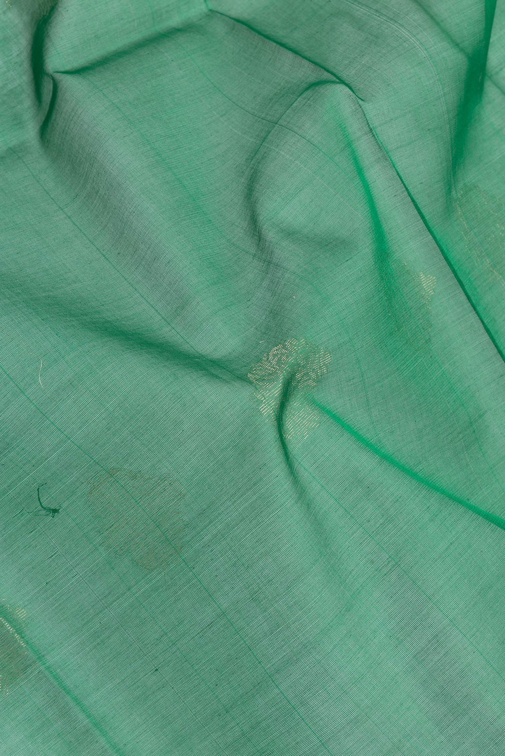 Close up of Green Silk Cotton Saree with Zari Butta on the body and Zari Border.  displaying folds
