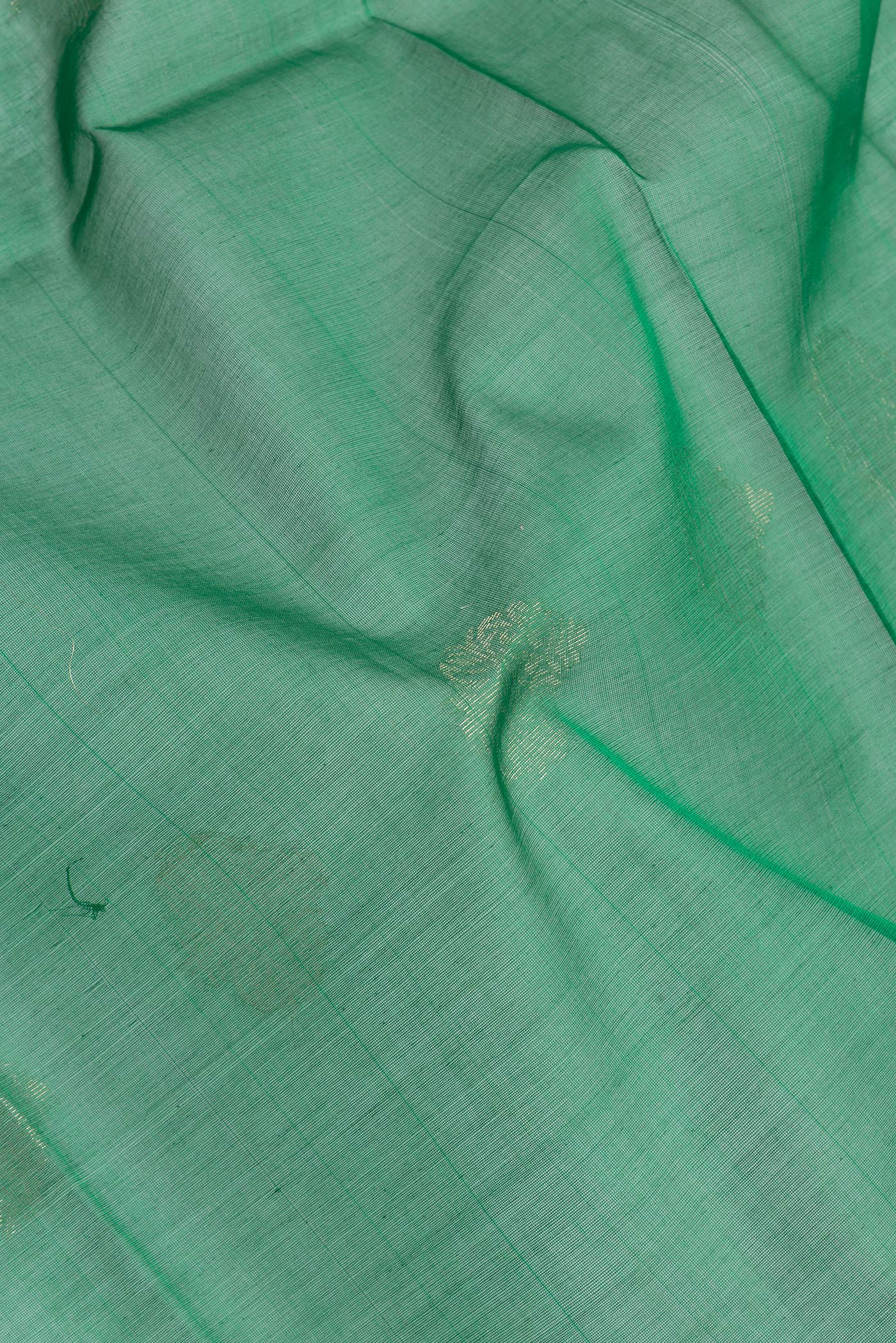 Close up of Green Silk Cotton Saree with Zari Butta on the body and Zari Border.  displaying folds