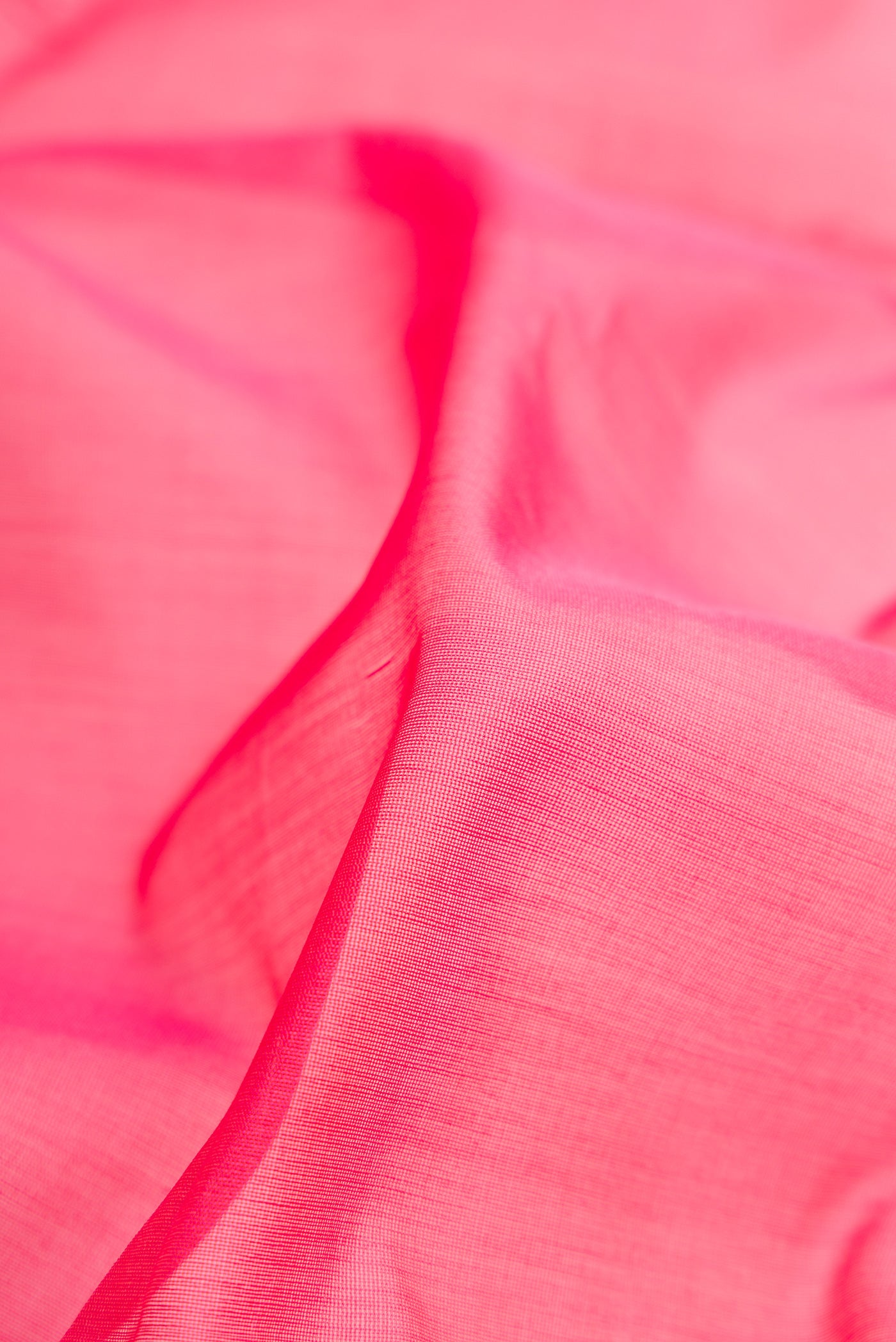 Close up of Pink Silk Cotton Saree with Plain Body and Fancy Border.  displaying folds