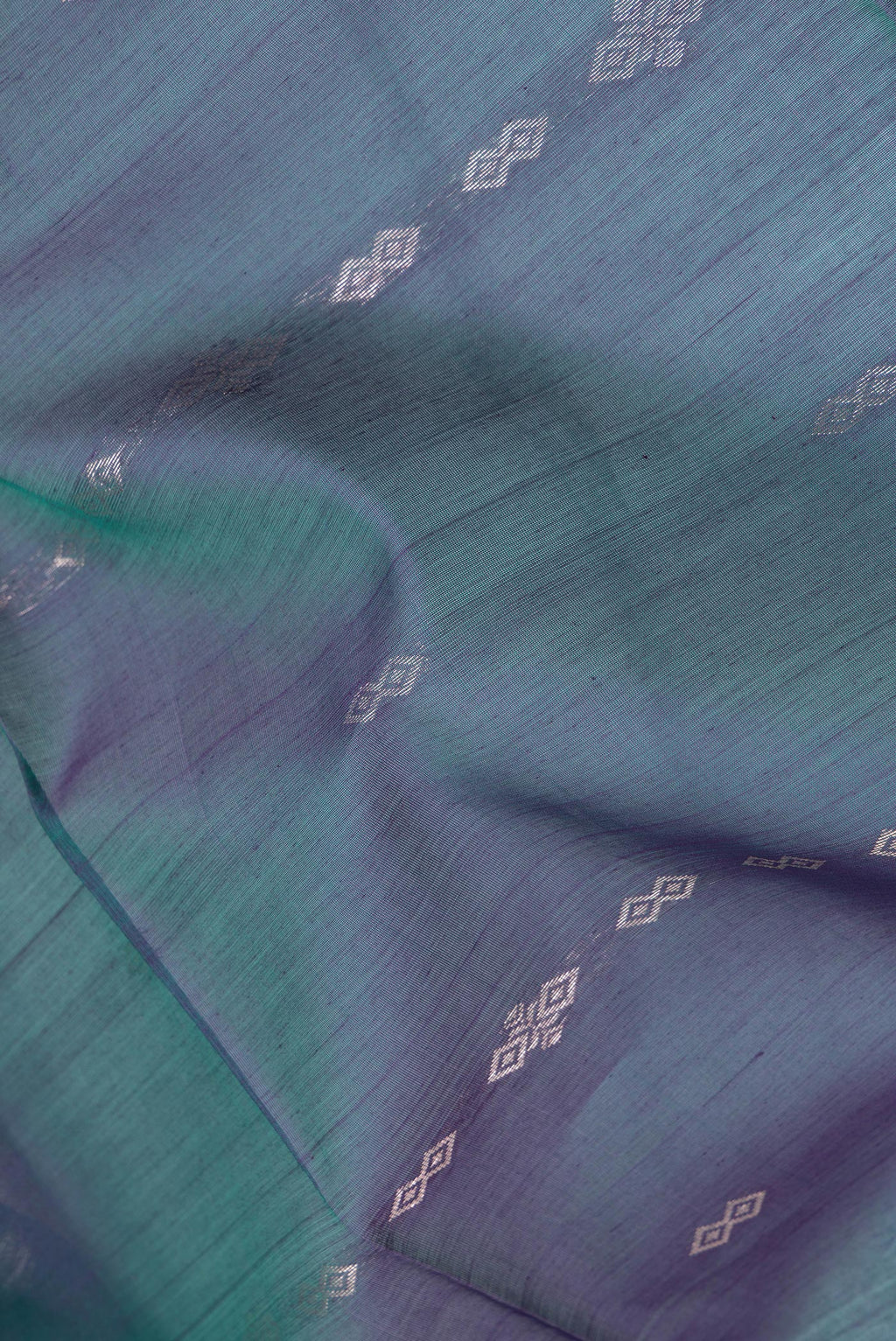 Close up of Peacock Blue Dual Tone Silk Cotton Saree with Zari Butta on the body and Zari Border.  displaying folds